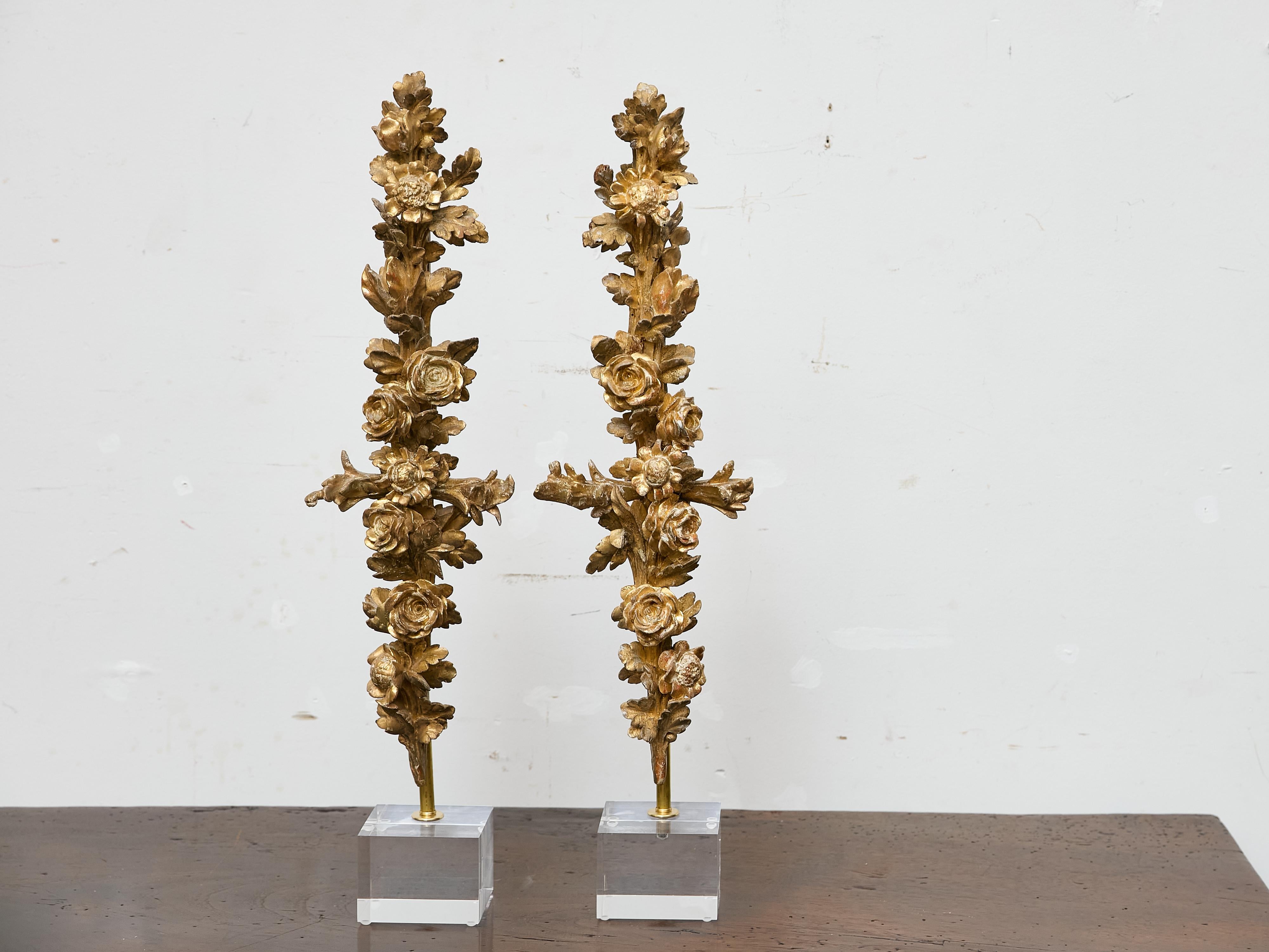 Ricca di dettagli e presenza decorativa, questa coppia di sculture in legno dorato del XIX secolo presenta una lussureggiante cascata di rose e fogliame in pieno rilievo. Originariamente concepite come elementi architettonici - forse una volta