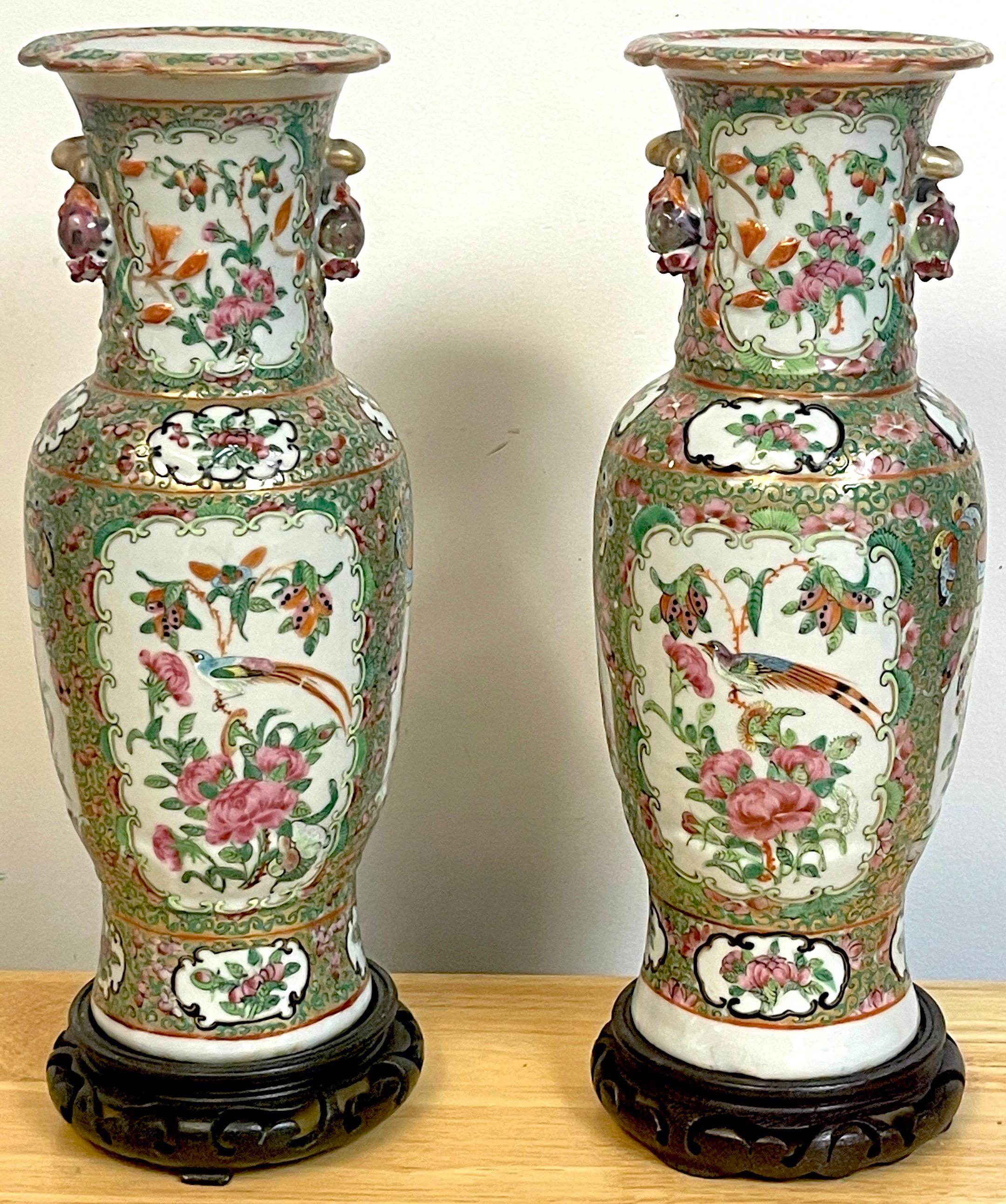 Pair of 19th century rose canton vases & stands, each one profusely decorated with vignettes of birds and florals to the fronts and backs. The sides with applied pomegranate handles, the lower decorated with foo dog handled vases. Truly unusual