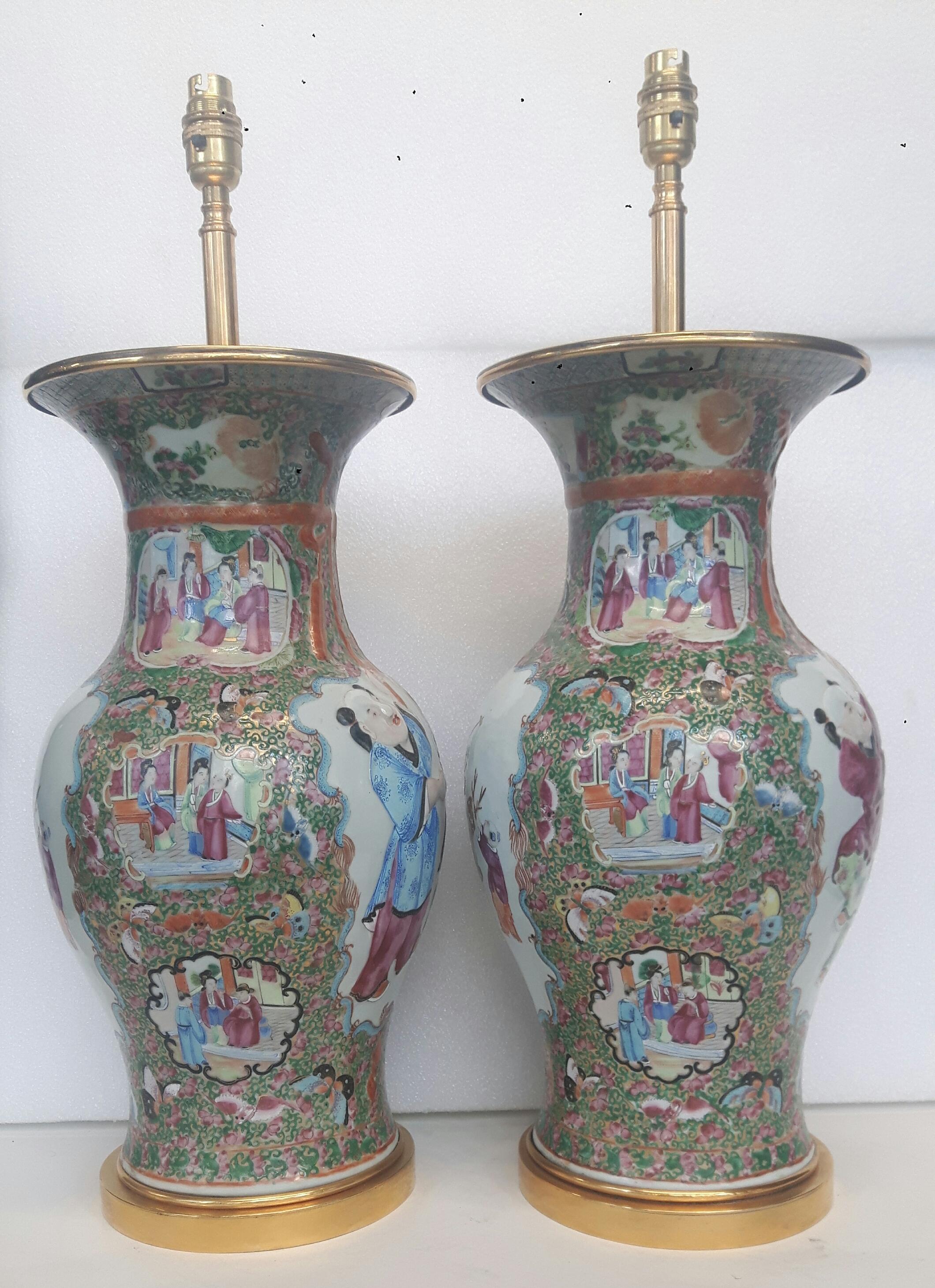 Pair of rose medallion baluster vases with vignette of Chinese hehe twins in molded relief on one side and on the other depicting ladies and a deer. Converted to lamps. Including lamp fittings, vases are 61cm, excluding lamp fittings, they are 45cm.