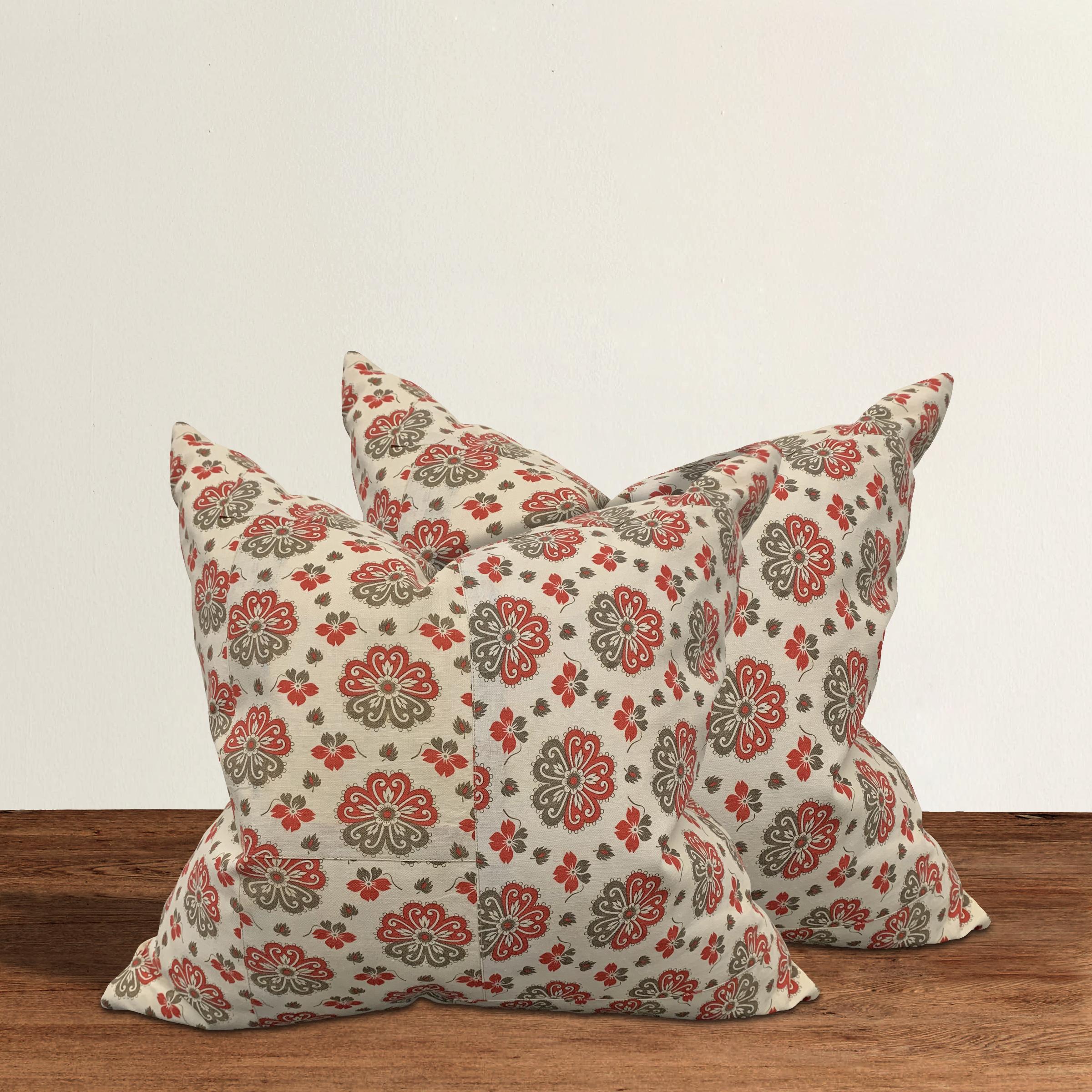 Pair of pillows made from 19th century Russian block printed cotton panels with large red and brown flowers, backed with solid linen and filled with down.