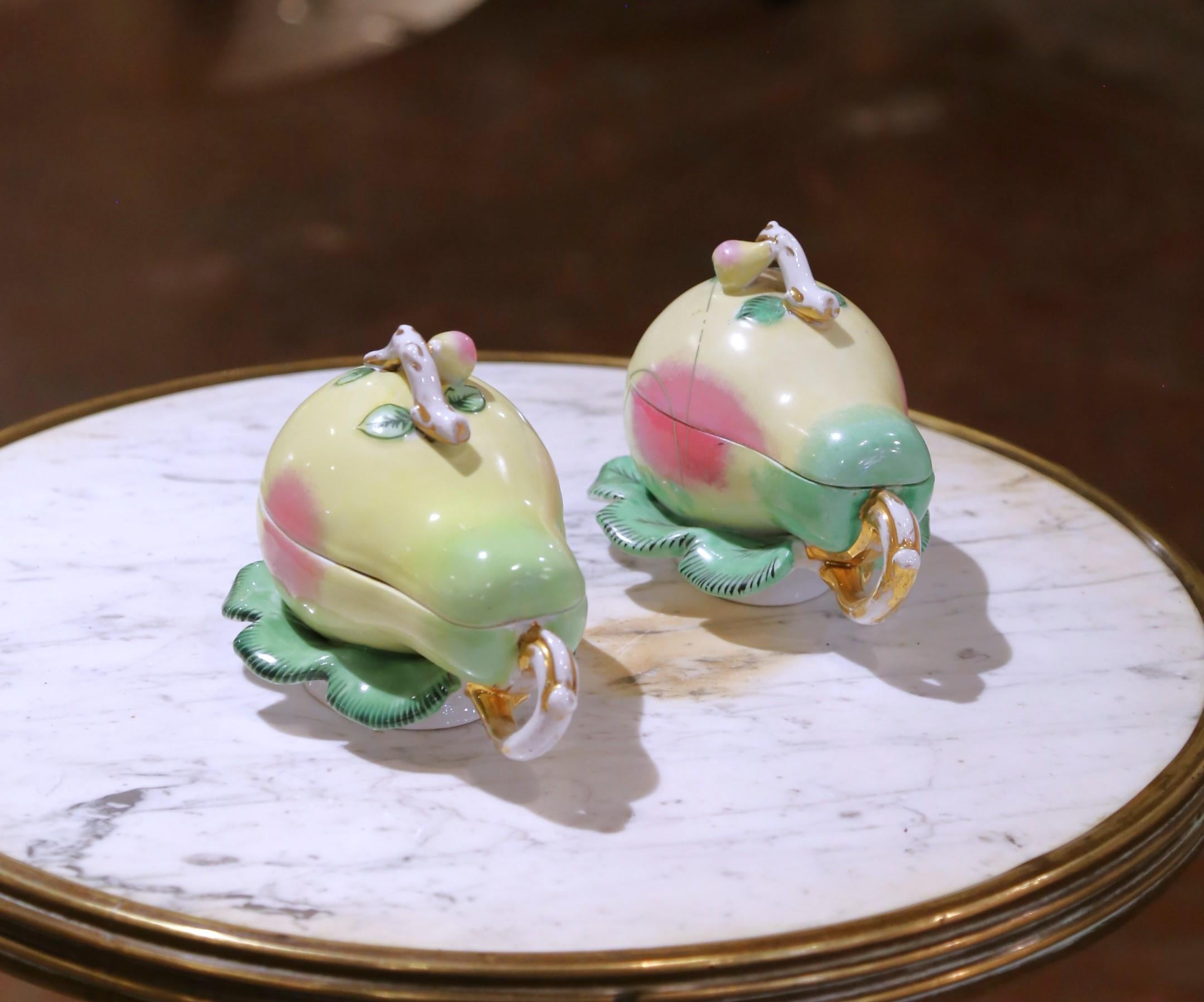 Whimsical yet elegant, this rare matched pair of pear-shaped covered tureens was crafted in Russia circa 1870 by the renowned Riga Kuznetsov Porcelain Factory. Expertly hand-painted, each tureen features a soft yellow and pale green ground with a