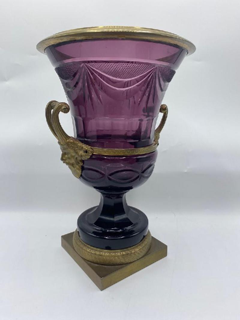 Pair of 19th Century Russian Ormolu Mounted Amethyst Glass Campana Vases. Each has an everted lip about a cut glass body. Bacchic mask twin handles on a faceted waist socle with milled base and square plinth. Russia, mid to late 19th century. Each