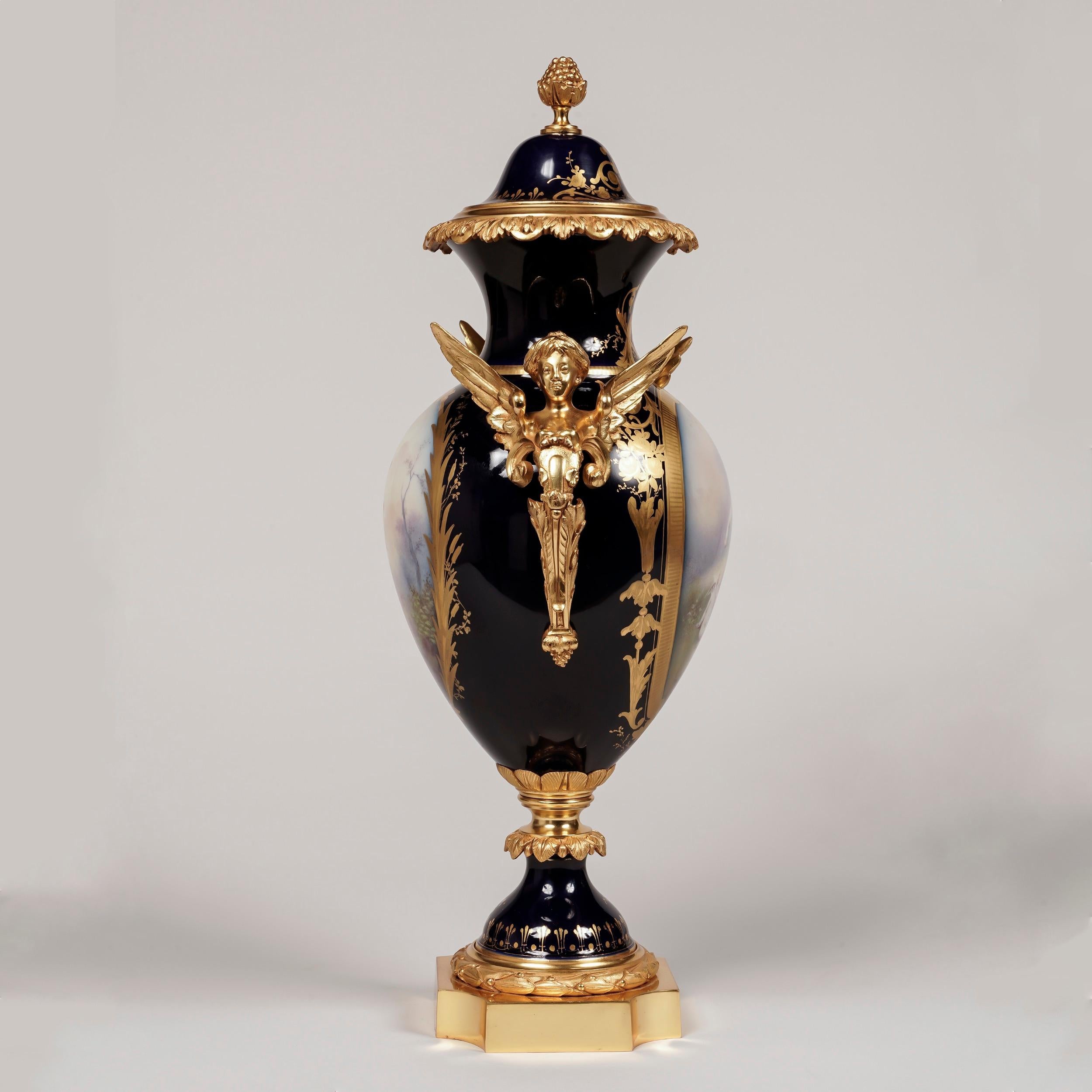Ein Paar in Ormolu gefasste Beau Bleu 'Sèvres' Porzellanvasen

Jede Vase steht auf einem quadratischen Ormolu-Sockel mit eingeschnittenen Ecken. Die Porzellan-Balusterkörper mit Ormolu-Doppelhenkeln, die als geflügelte Hermen modelliert sind, sind