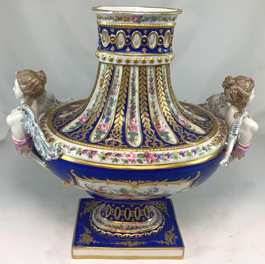 Pair of Sèvres 19th century hand painted reticulated covered urns. Restoration to both finials. Some rubs to gold and other minimal imperfections.
 