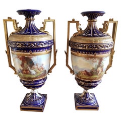Coppia di urne in porcellana di Sevres del XIX secolo dipinte a mano con decorazioni in cobalto e dorate