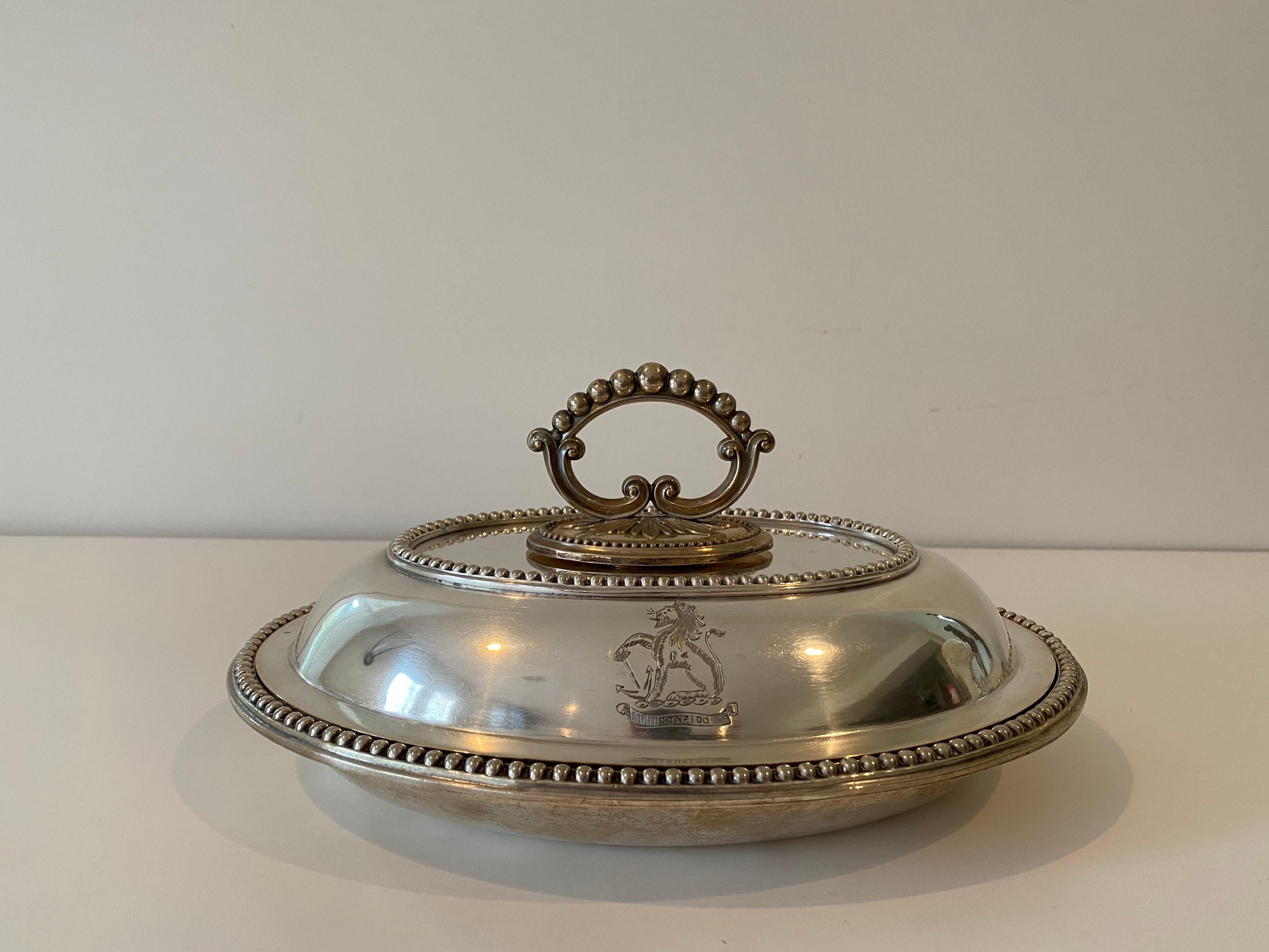 A pair of 19th century English Sheffield silver plated covered tureens. Heavy construction with beaded trim, removable scrolled acanthus design handles for storage and engraved lion crest 