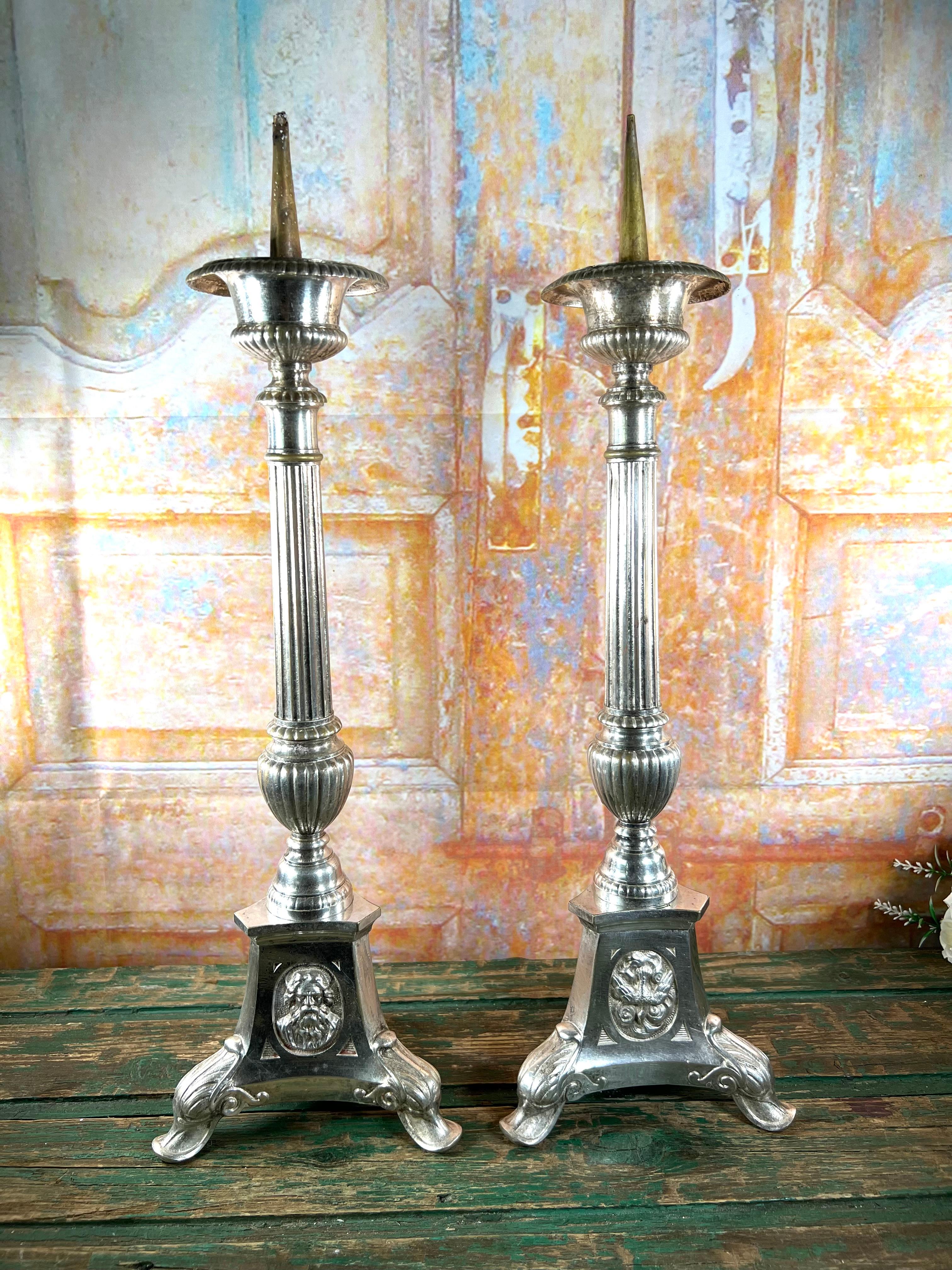 Questa splendida coppia di candelieri da altare in metallo argentato del XIX secolo emana un'eleganza senza tempo e un profondo simbolismo. Caratterizzati da una colonna centrale splendidamente lavorata, i candelieri poggiano su una notevole base