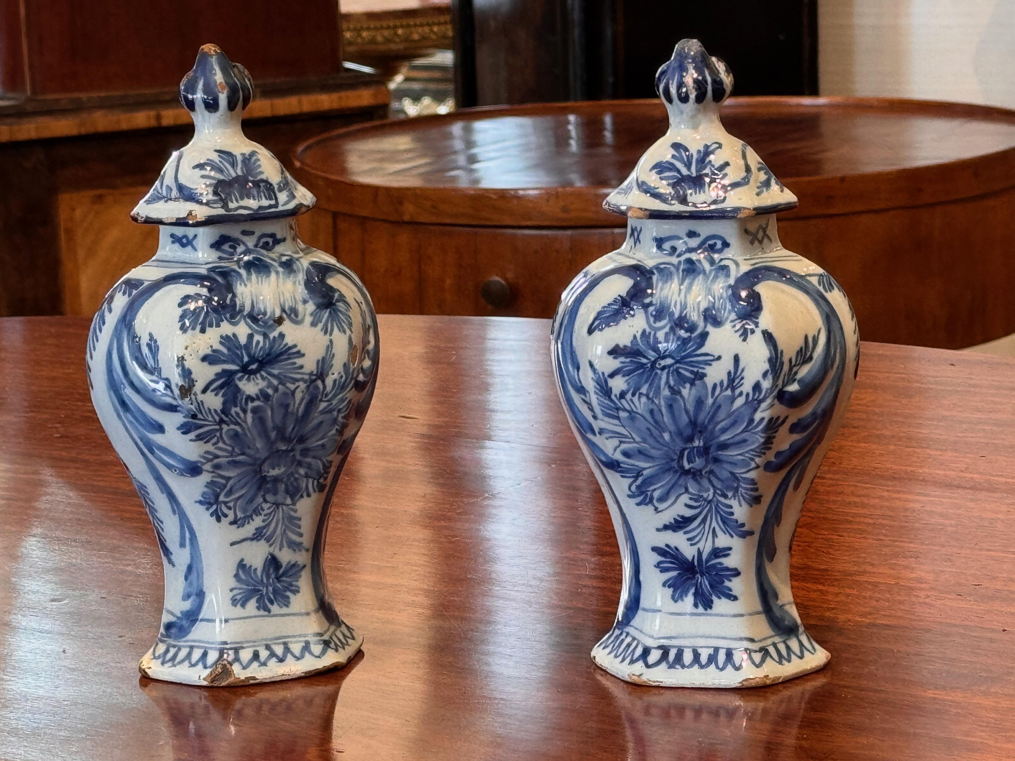 A small pair of scenic delft urns. The lids are attached.