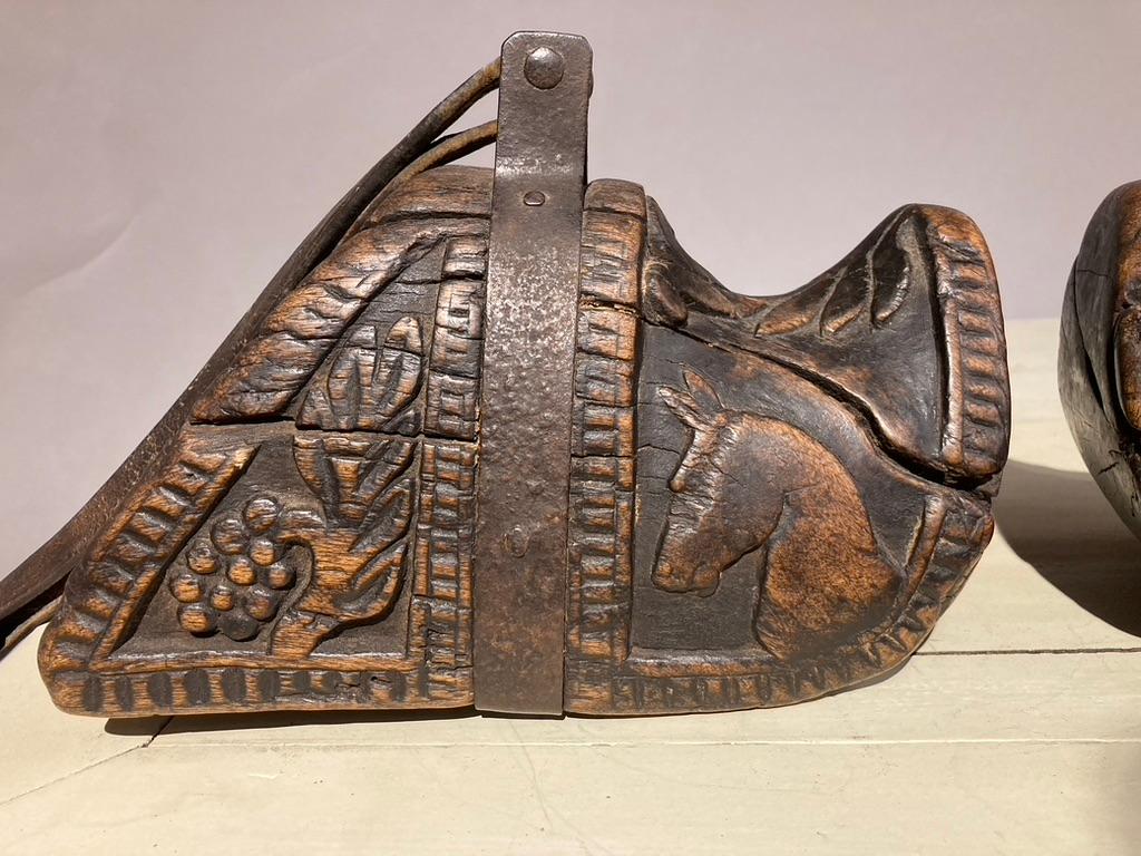 Fantastic pair of 18th-19th century South American carved wooden stirrups. Known as estribos, each are carved from a solid block of wood. Decorated with wonderful carvings of horse heads and grape vines, these are truly charming pieces of Folk Art.