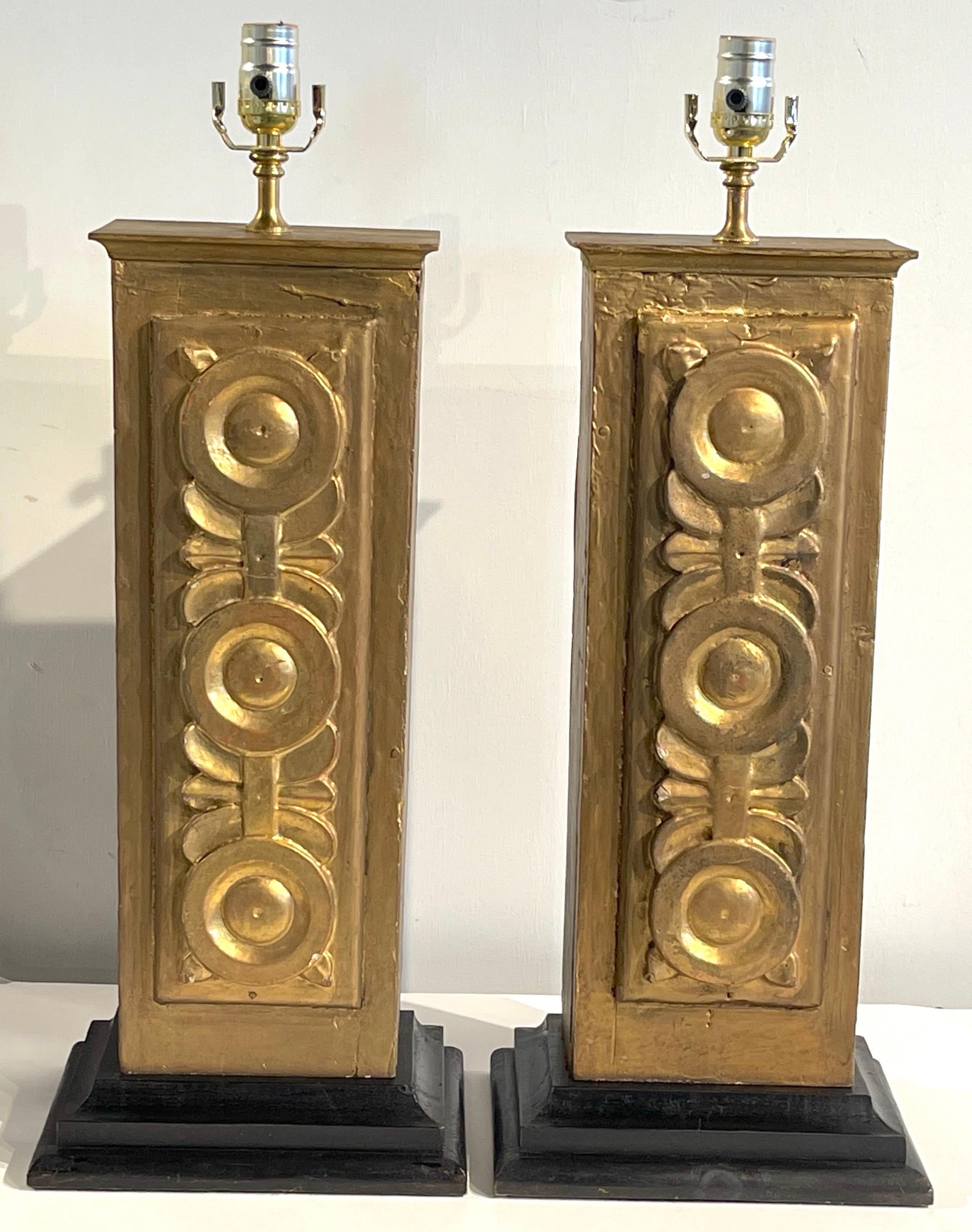 Pair of 19th century Spanish colonial giltwood columns, now as lamps 
Spain, 19th century 

Each one with a good antique patina, with three carved stylized rosettes, raised on a later ebonized wood base, newly wired.

Measurments
26-inches
