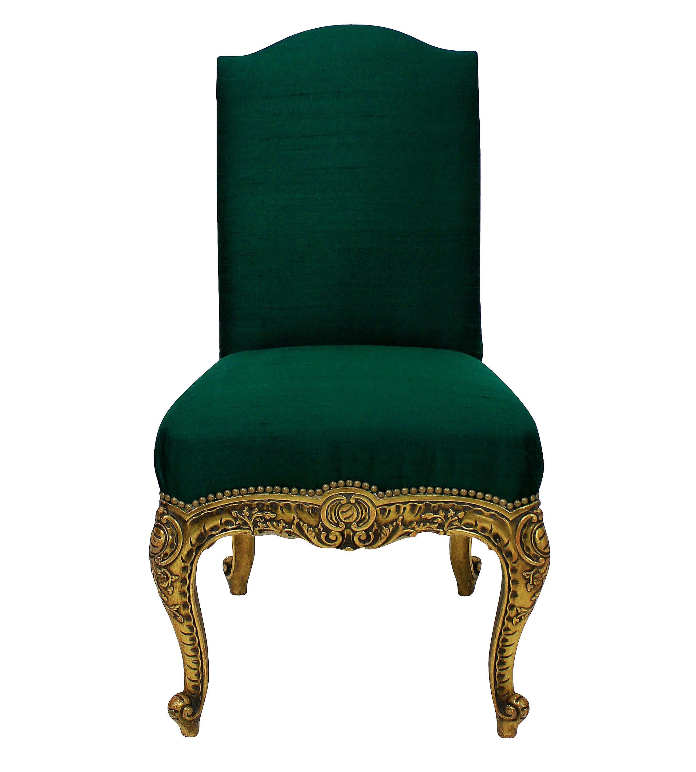 A pair of Spanish carved giltwood side chairs with cabriole legs and newly upholstered in emerald silk with gold studding.
 