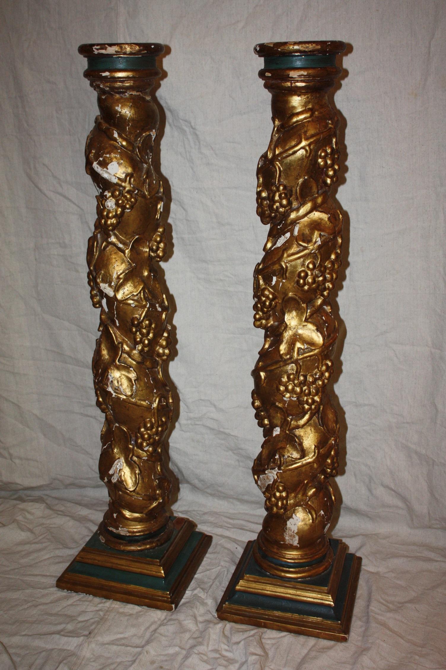 Beautiful pair of carved wooden column with traces of original color and gilding, weathered, with small losses.