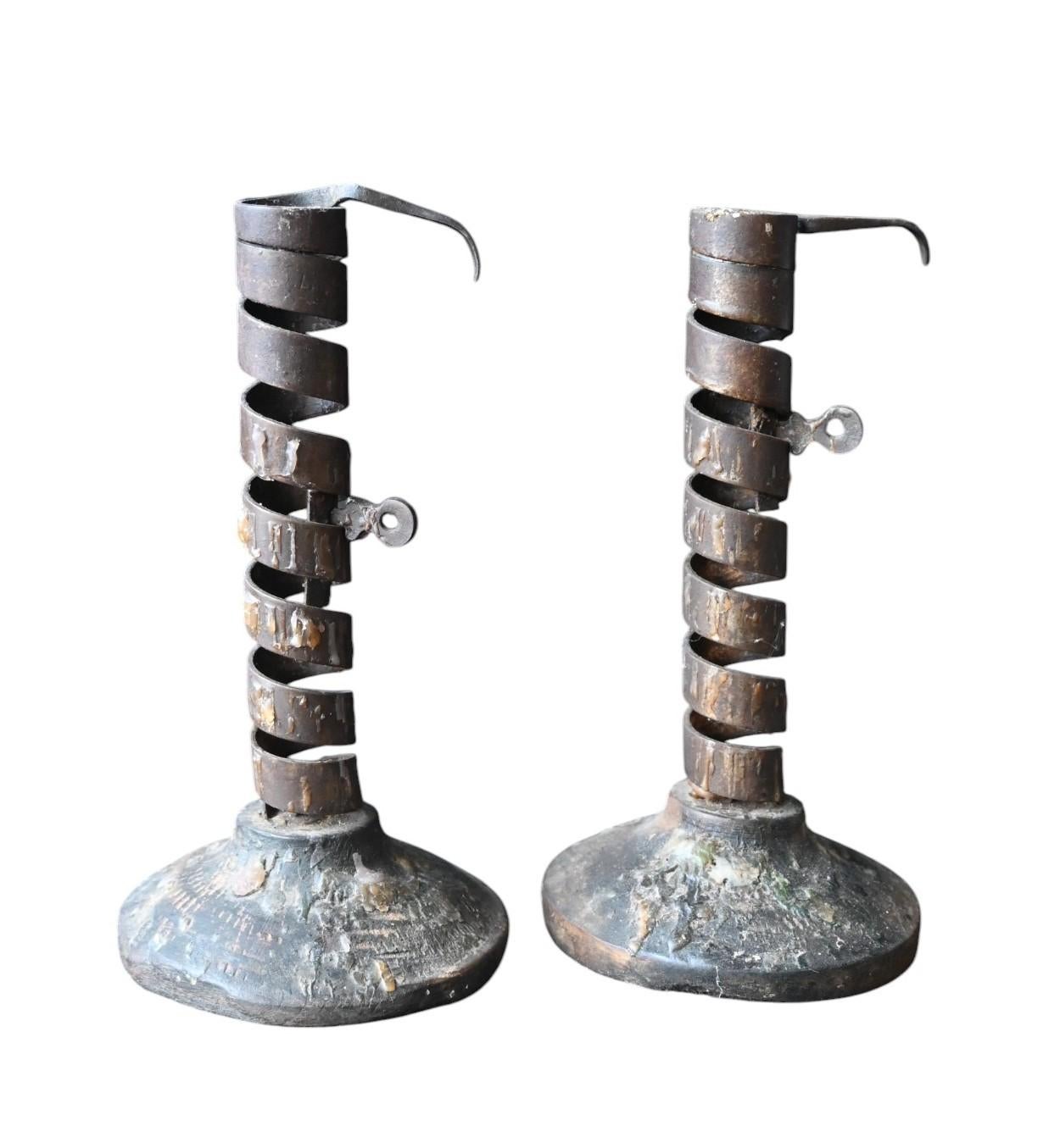 Encantadora pareja de antiguos candelabros en espiral de hierro forjado, del siglo XIX. Cada candelabro presenta un distintivo vástago en forma de sacacorchos con un portavelas ajustable, accionado por una clavija lateral que se encaja en las