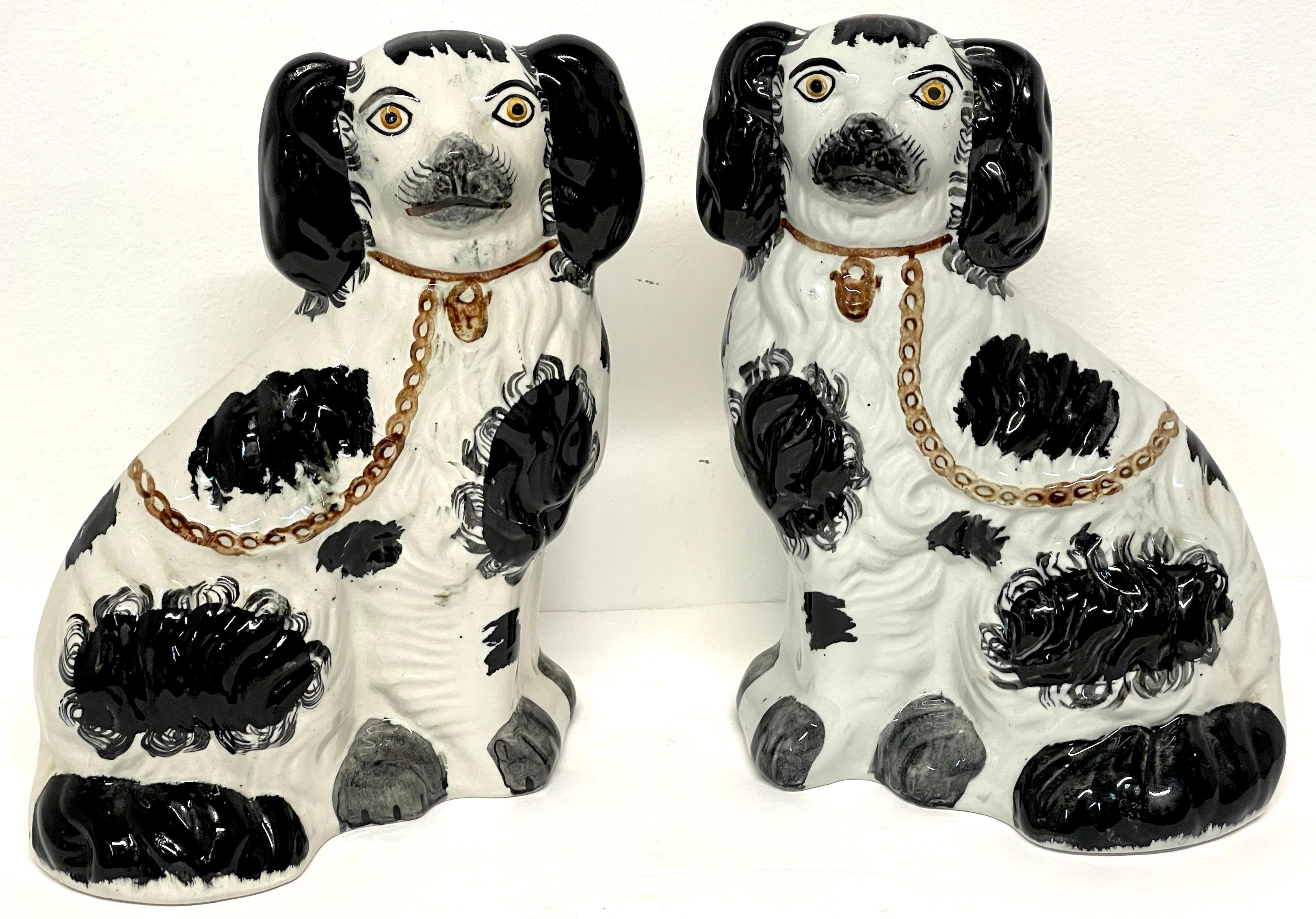 Pair of 19th century Staffordshire dogs, black & white 'Sponge' Decoration 
England, circa 1880s
A unique pair of well painted and enameled Staffordshire seated spaniels with chains. A variant with the decoration, more primitive, than usual. With