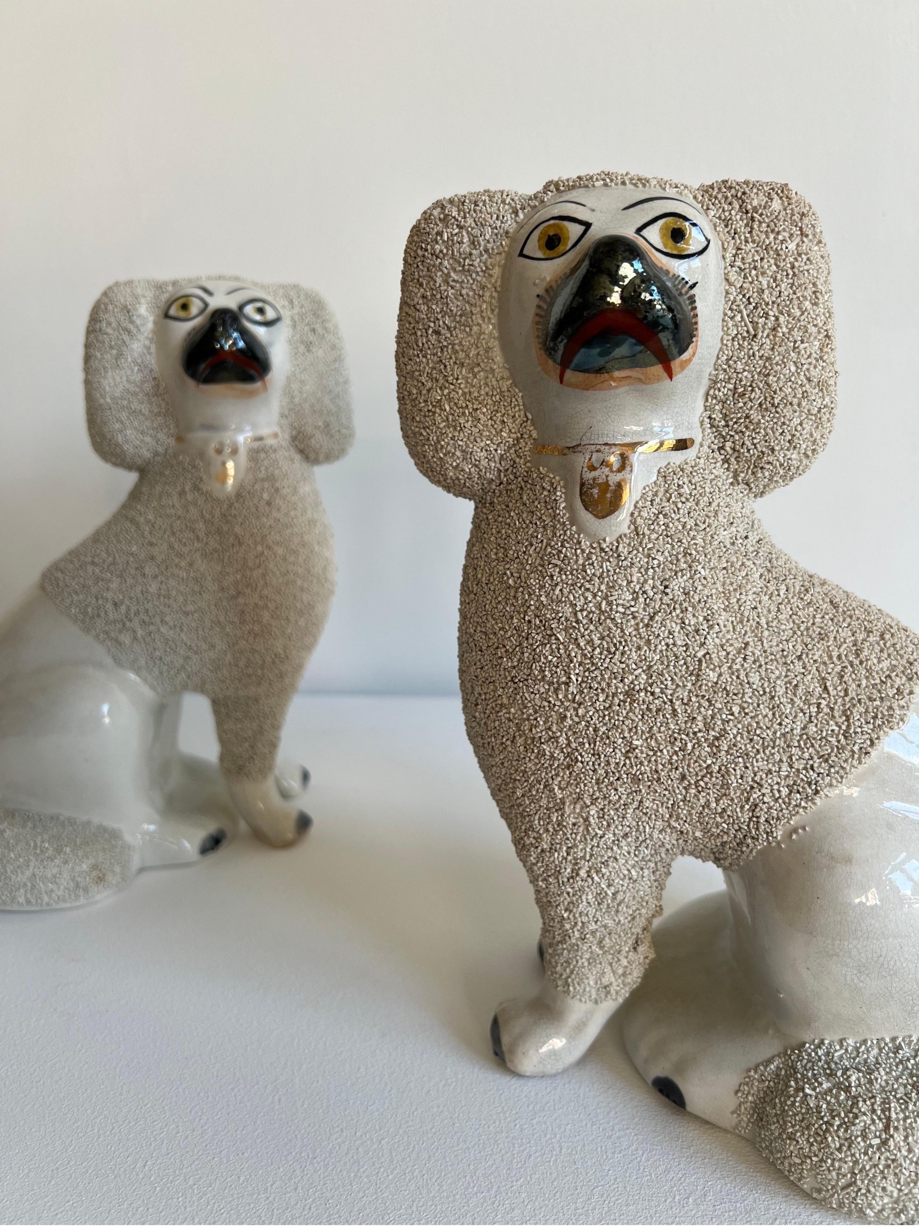 A superb pair of of 19th Century antique Staffordshire Poodles with chip-glazed coats, applied by hand, and separately moulded front legs. Both wear gilded collars and have hand painted faces and paws.

In great condition for their age.

H: 24cm x