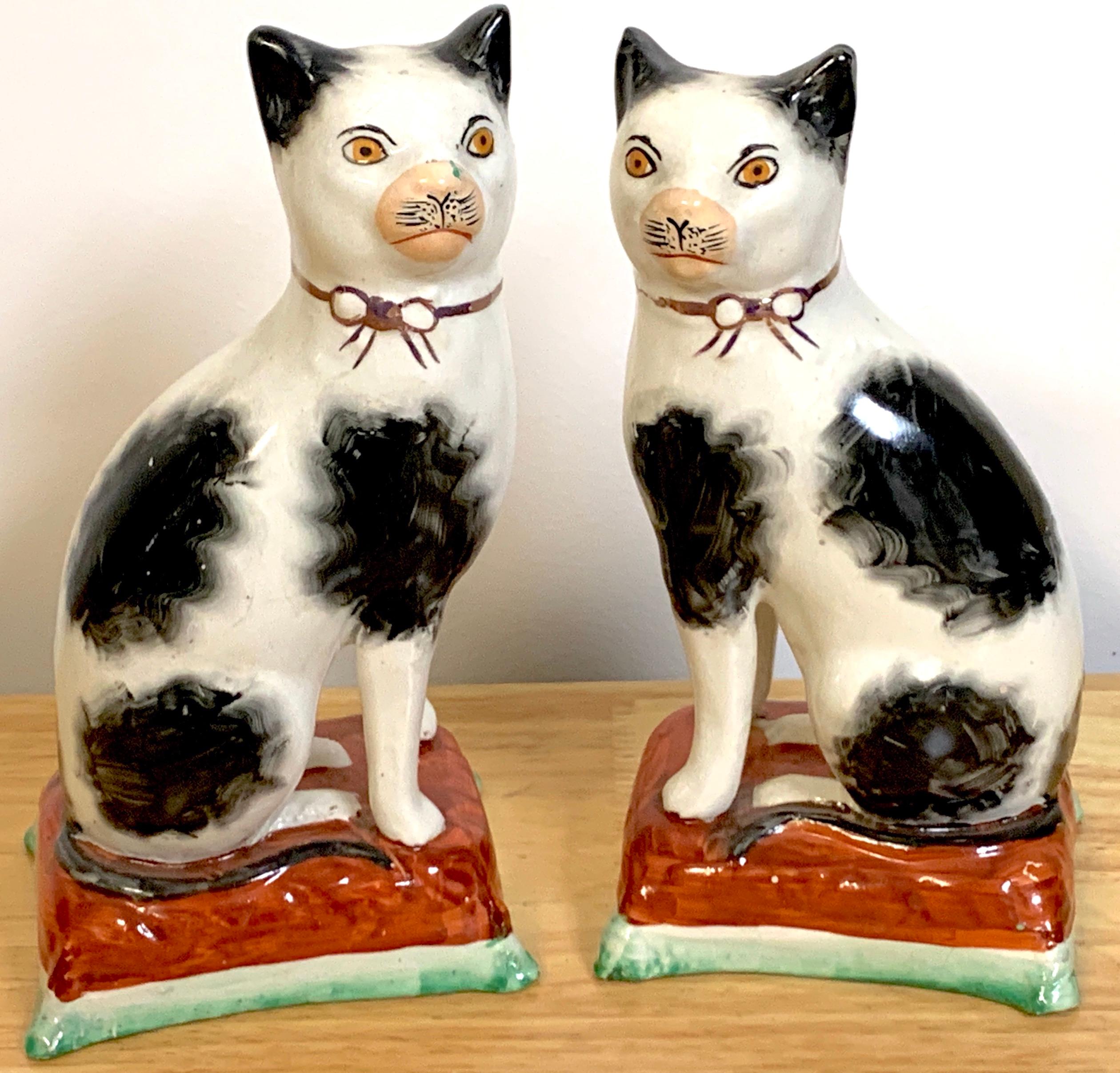 Pair of 19th century Staffordshire seated cats, each one an expressive black and white feline, sitting on a tasseled cushion. Unmarked, circa 1860
Each one measures 7.5-inches high x 4-inches wide x 3-inches deep.
  