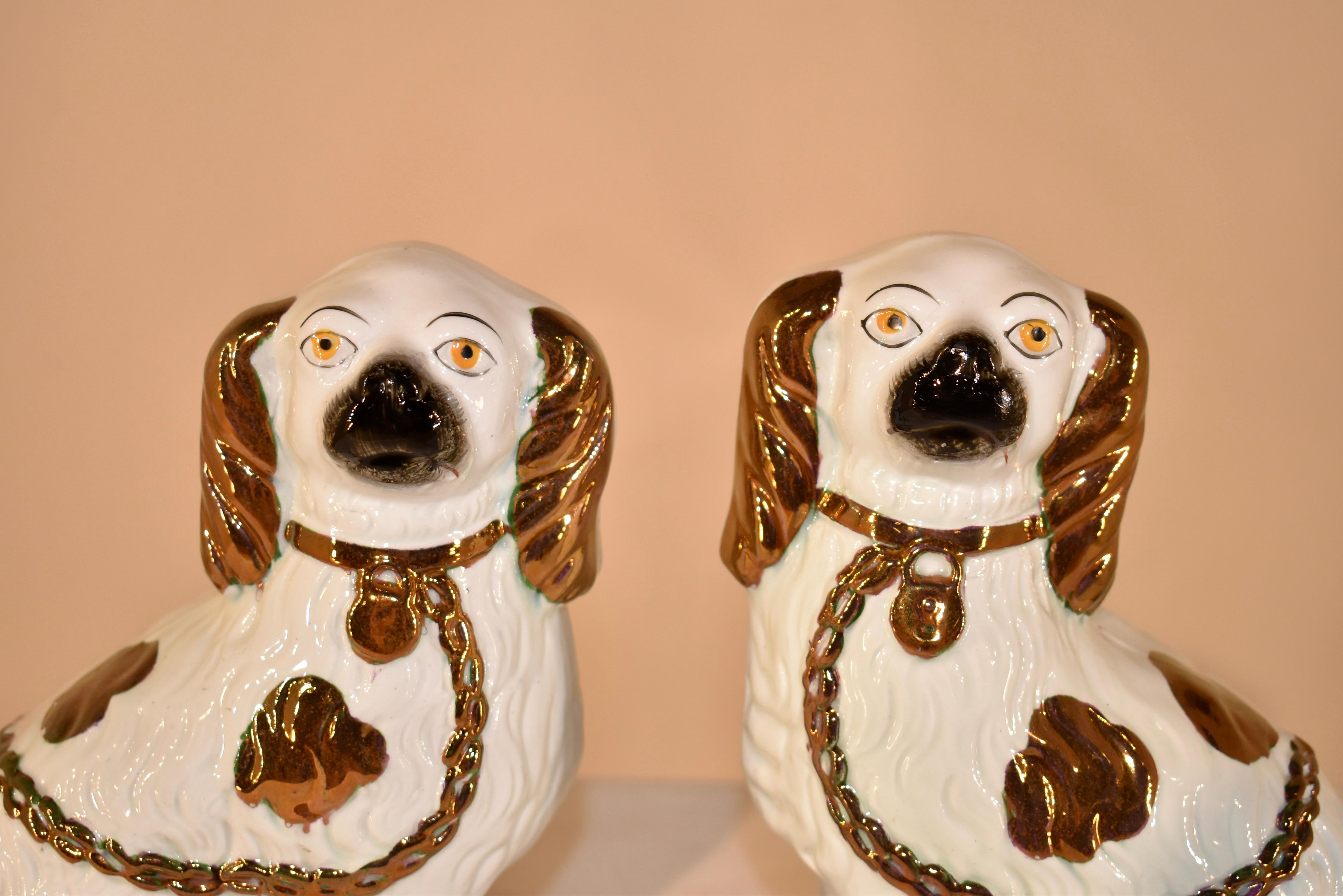 Pair of 19th century Staffordshire spaniel figures with separated front feet.  This pair of dogs has wonderful hand painted copper lustre decoration.  The dogs with separated legs are more rare and much harder to find.