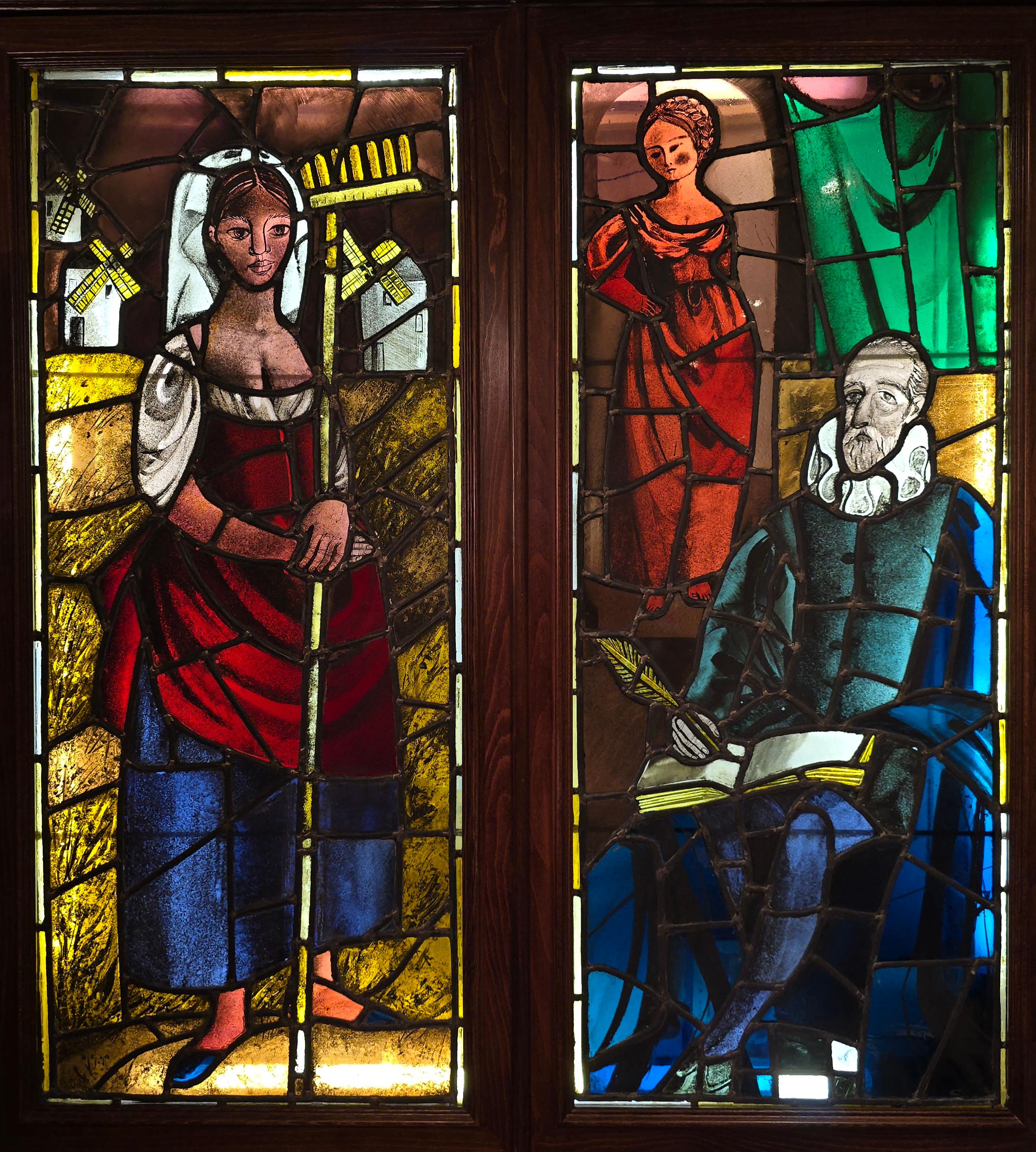 This decorative pair of stained glass panels features scenes inspired by the iconic Spanish literary character Don Quixote. Created in the 19th century, the glass pieces are artistically crafted and joined with lead, showcasing the intricate