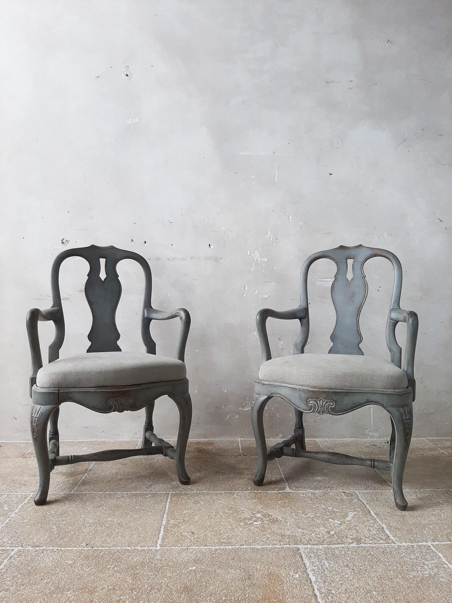 Pair of 19th century Swedish armchairs. These antique wooden chairs have a beautiful carved detail on the front and legs. The look stylish with the old gray patina and new gray upholstery.

Measure: H 98 x W 60 x D 50 cm
seat height 50 cm.