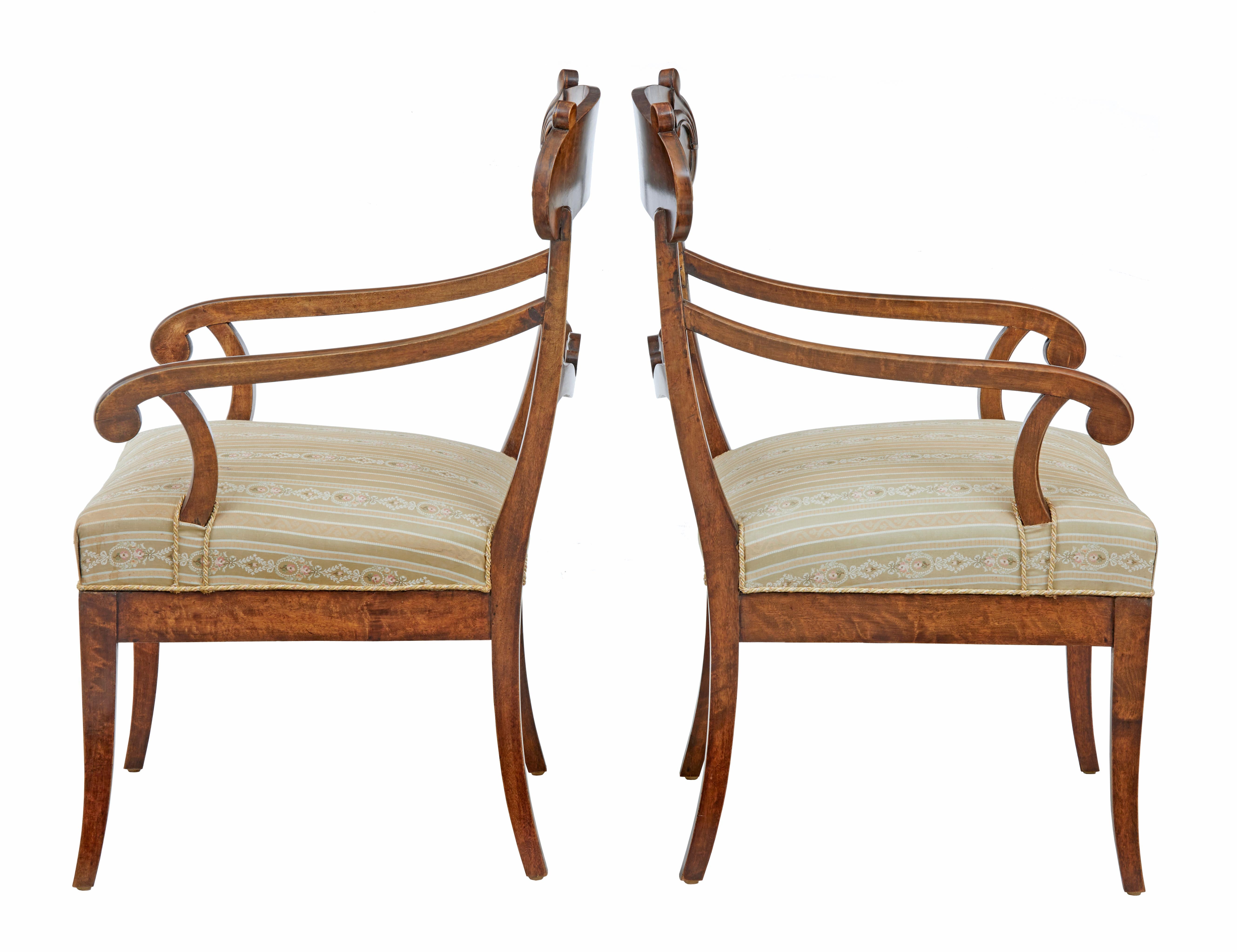 Elegant pair of Swedish dark birch armchairs, circa 1880.

Shaped backs with carved scroll back rest. Scrolled arms lead down to the over stuffed seats. Standing on tapering legs.

Dark stained birch, seats covered in complementary fabric with