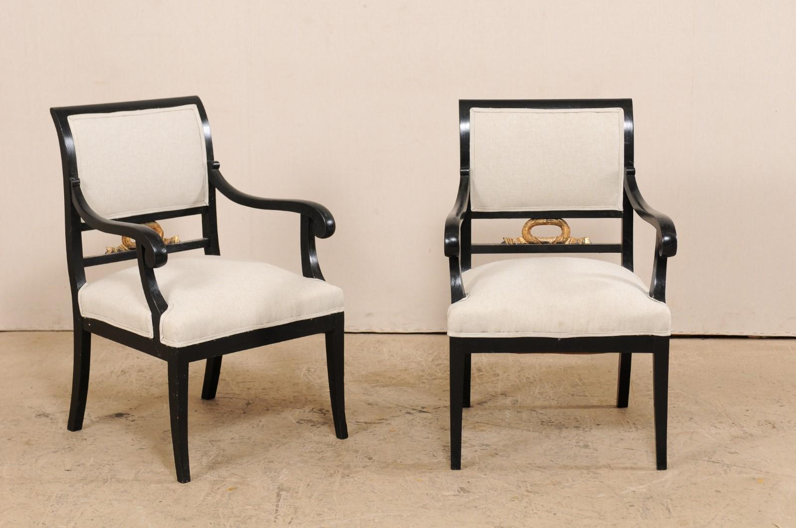 A pair of Swedish Empire armchairs from the mid-19th century by furniture maker F. Pettersson. These antique chairs from Sweden have an elegantly curved backs, with straight wooden top rails framing their upholstered backs which have an open area