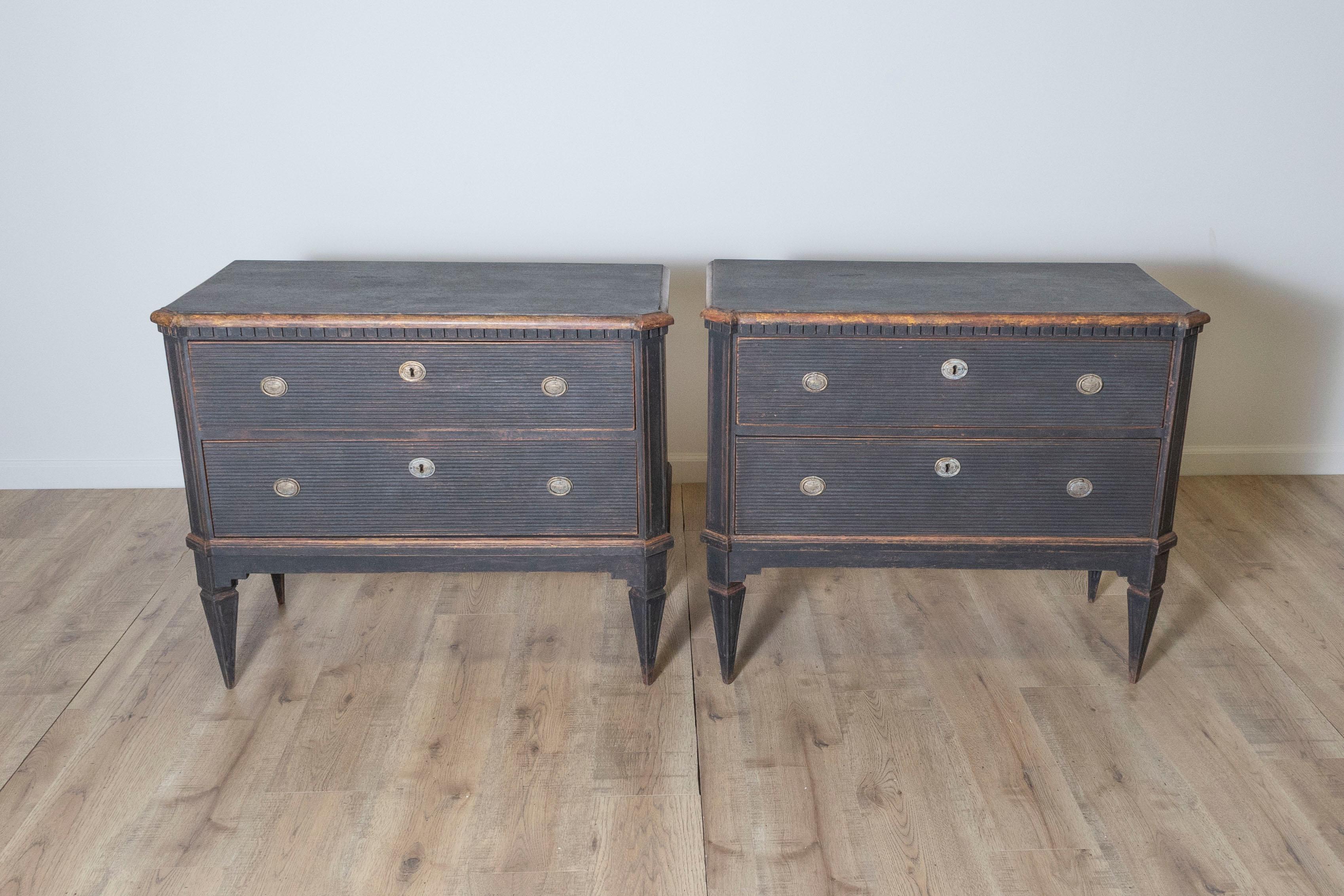 This exquisite pair of 19th century Gustavian-style chests of drawers showcases the elegance and craftsmanship characteristic of Swedish furniture design. Constructed from pine wood, these chests feature a striking black painted finish, enhanced by