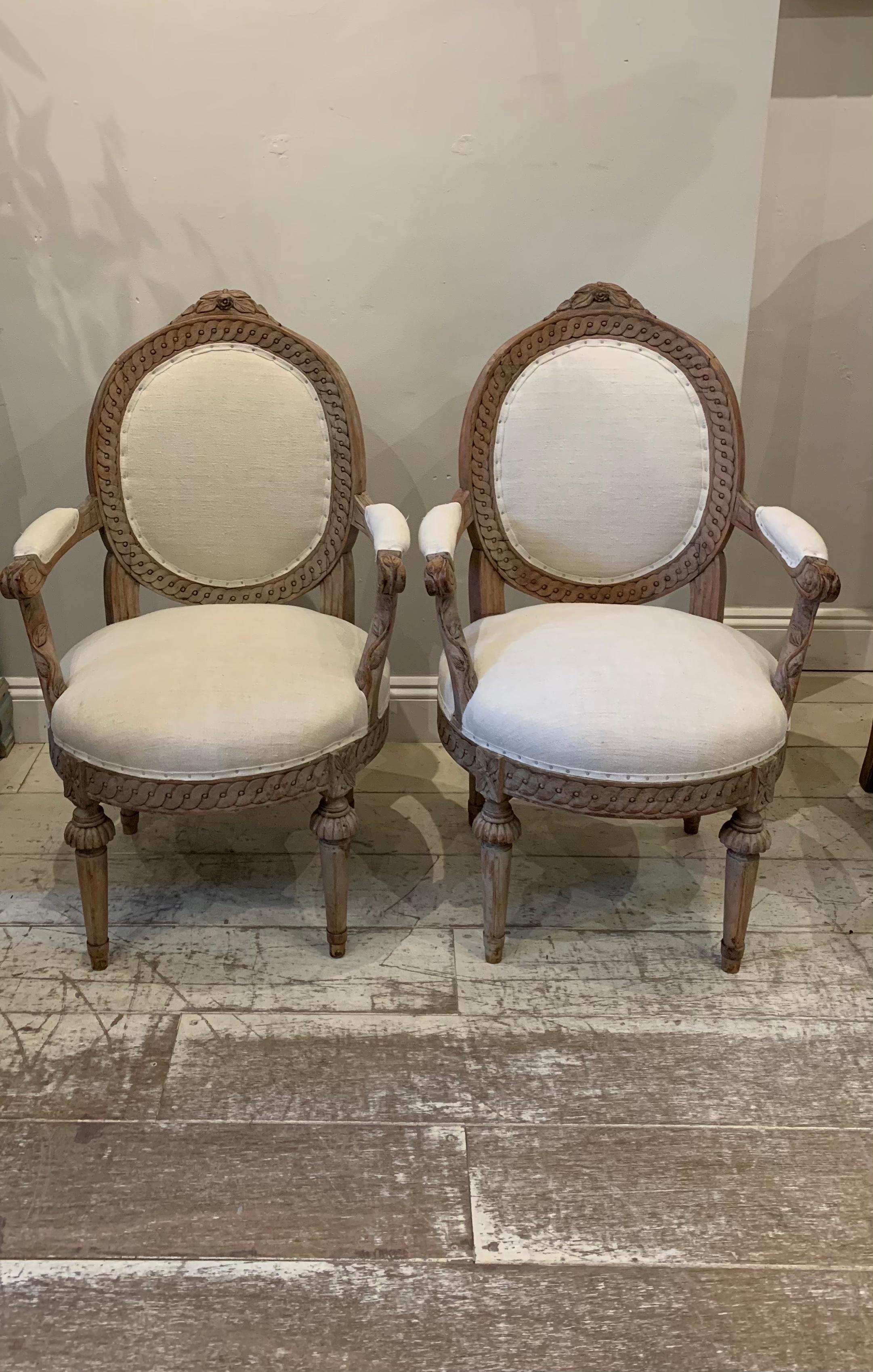 A pair of unusual Circa 19th century Swedish armchairs or side chairs.
The armchairs have been newly reupholstered in a neutral vintage French linen which complements the hand-scraped framework that still retains some slight traces of the original