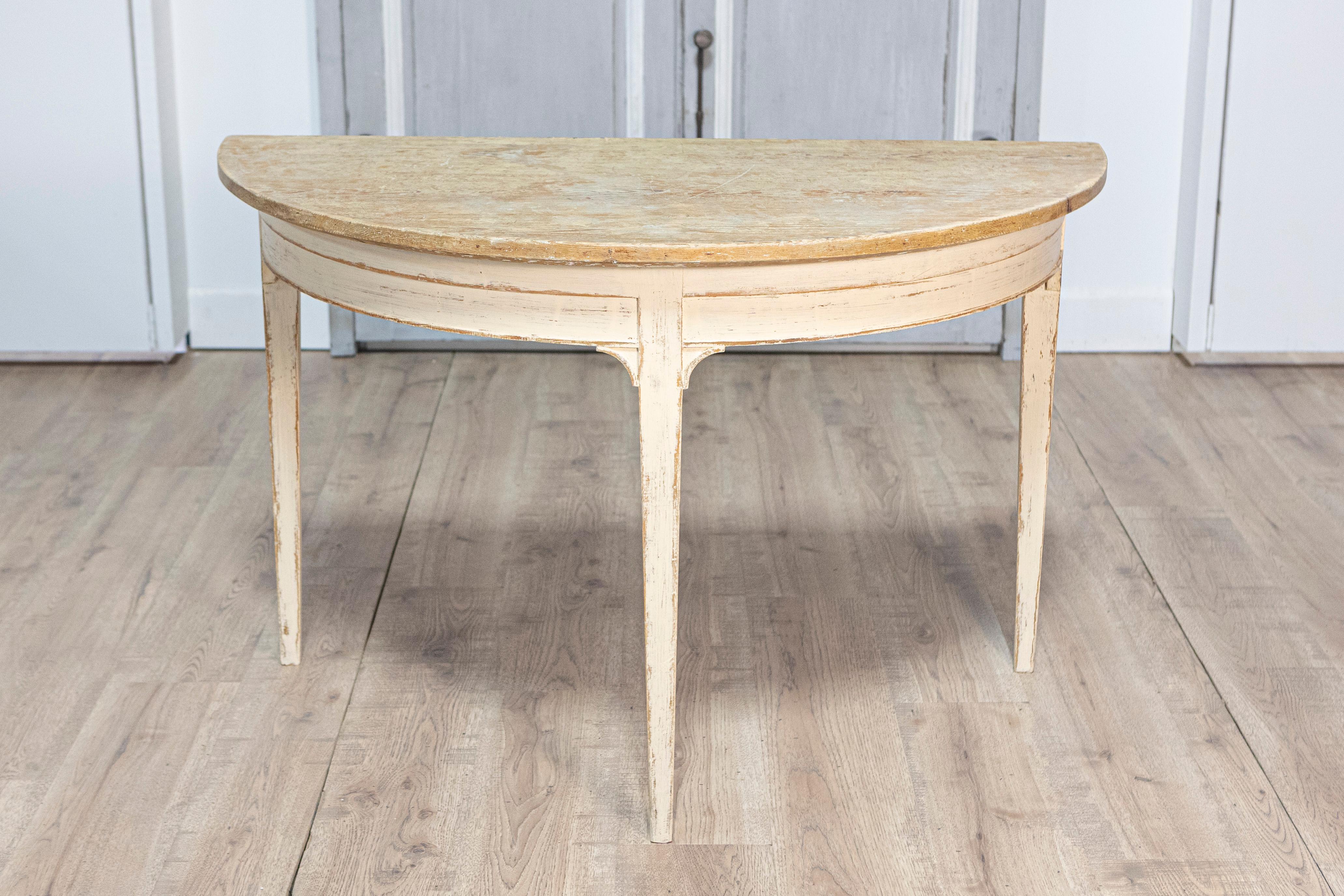 Dieses elegante Paar schwedischer Demi-Lune-Konsolentische aus dem 19. Jahrhundert verkörpert die zeitlose Raffinesse des Gustavianischen Designs. Die aus Kiefernholz gefertigten Tische verfügen über anmutig geschwungene Halbmondplatten und zart