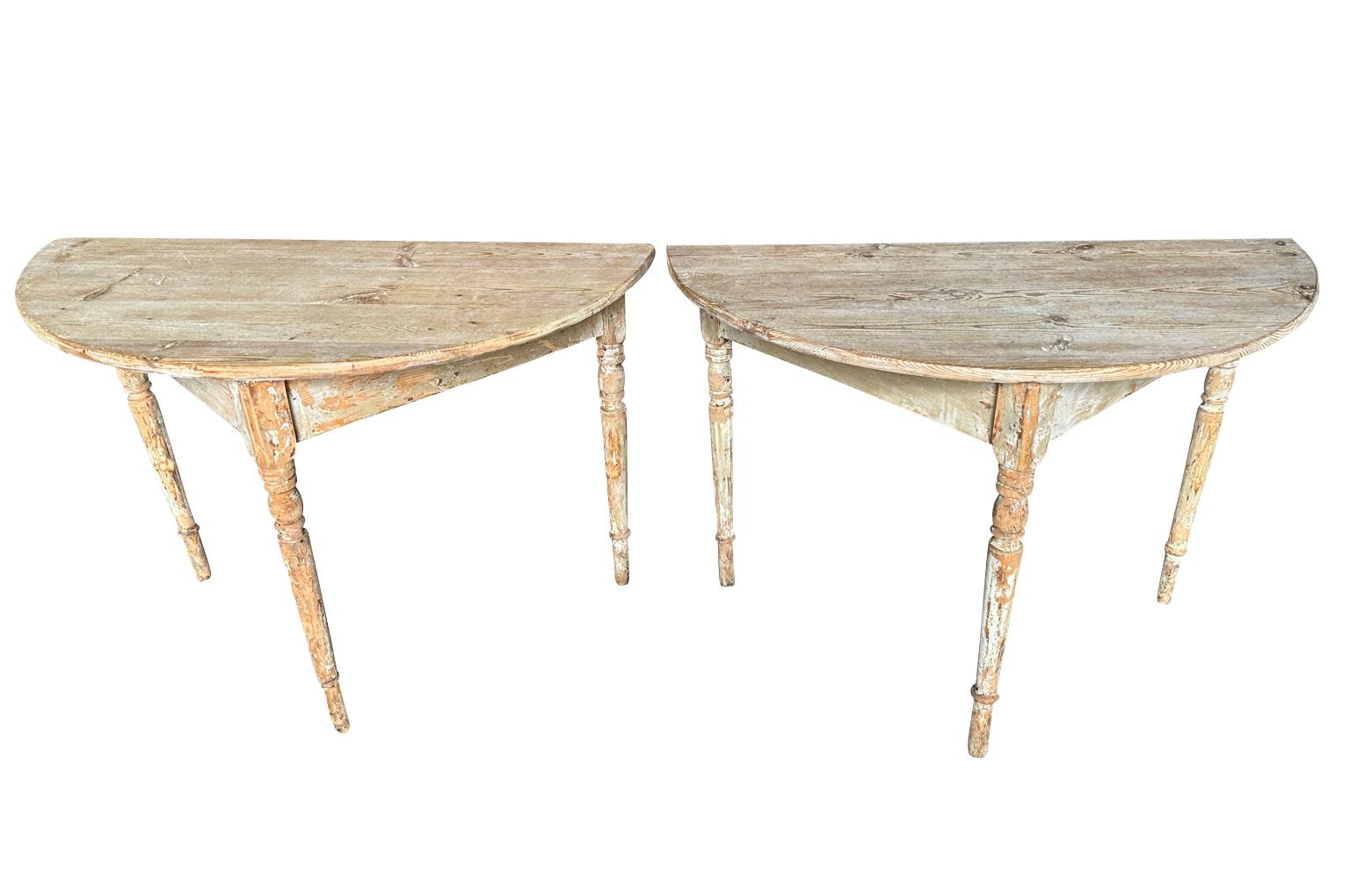 A very charming pair of 19th century Swedish Demi Lune Console Tables soundly constructed from scrapped wood with nicely turned legs.  Terrific finish and patina.
