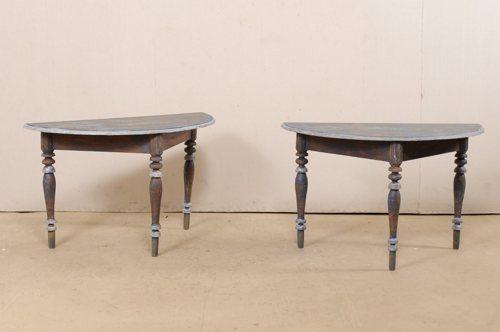 A pair of 19th century Swedish painted wood demilune tables. This pair of antique demilune tables from Sweden each features semi-circular tops over triangular-shaped aprons, which are presented upon three shapely legs which are nicely turned and