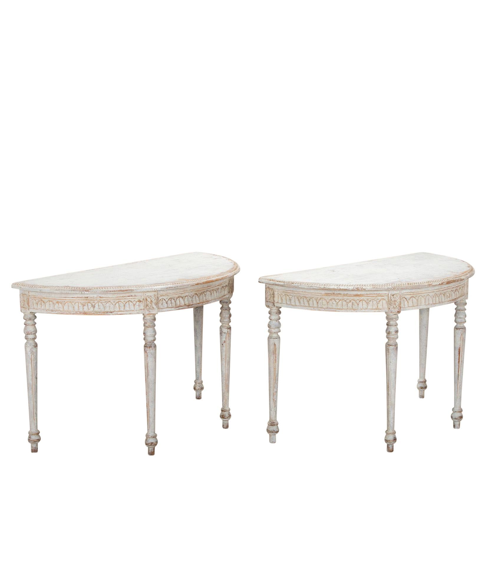 Pair of late 19th Century Swedish demi lunes.
With decorative carved acanthus leaf detailing to the front edge and legs and repainted in soft grey.
Circa 1880.