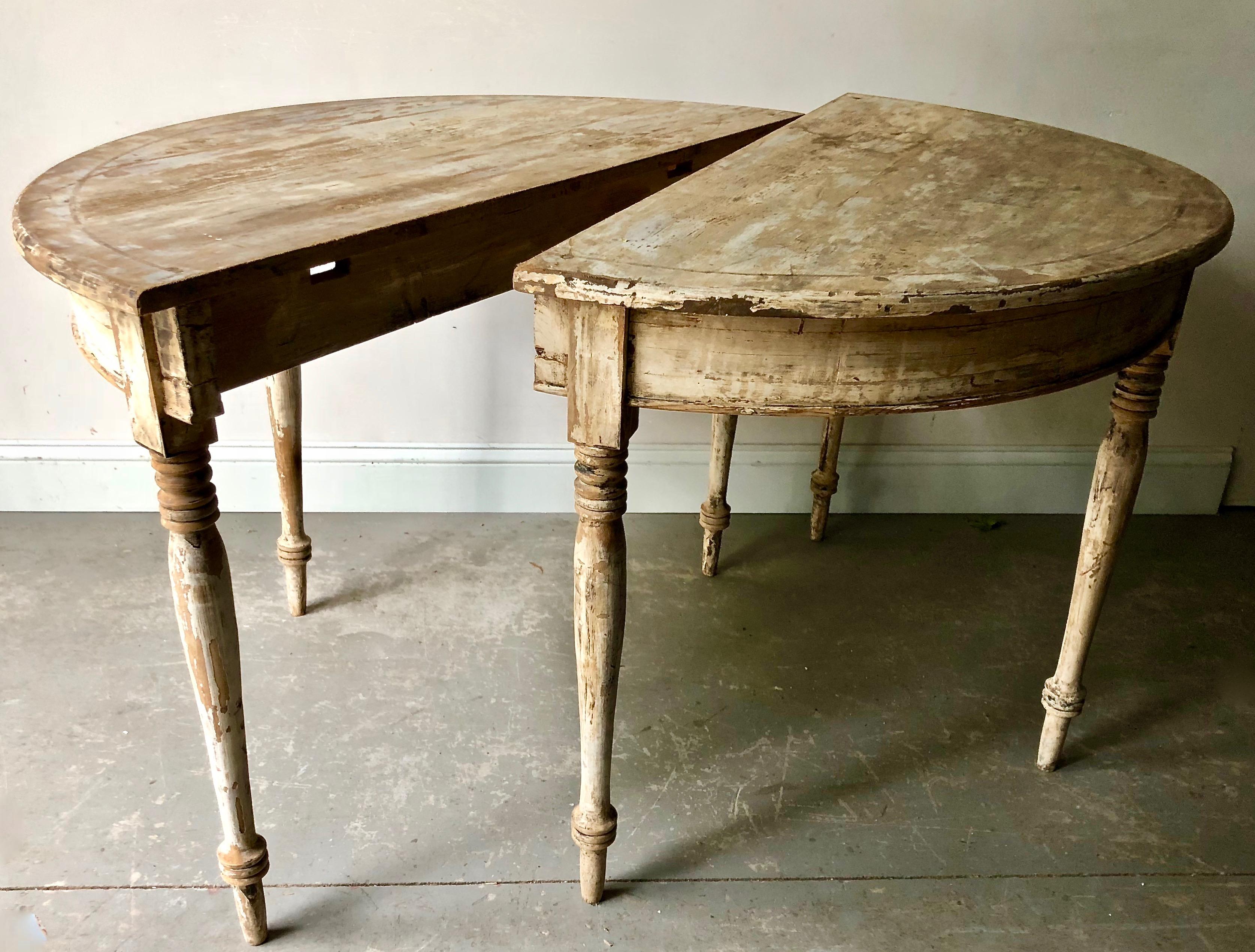 A handsome pair 19th century Swedish demilune tables with turned, tapered legs scraped back to traces of it's original color. 
Sweden, circa 1850.
Diameter when together 43.50