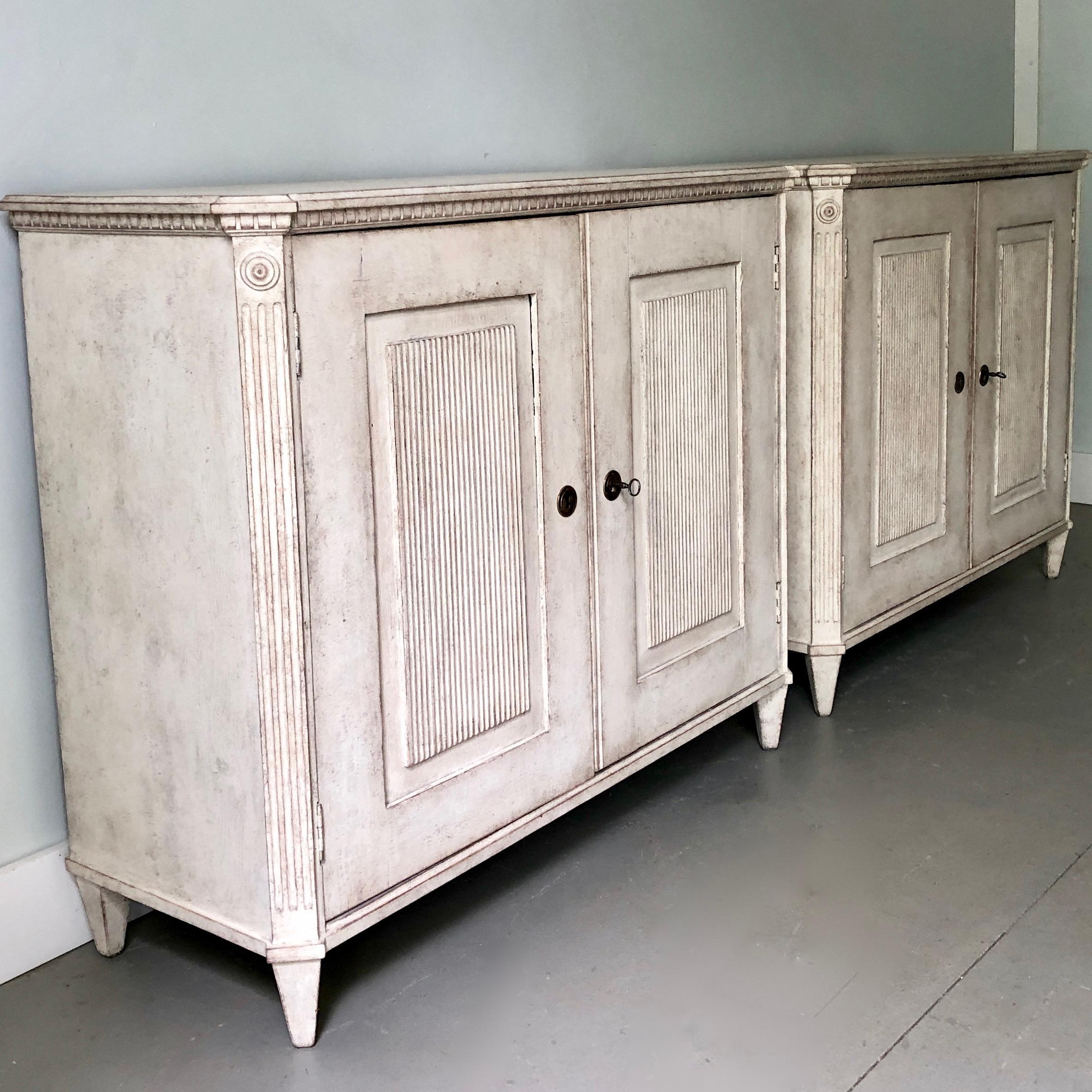 An elegant pair of Swedish Gustavian sideboard with beautifully carved, reeded and paneled door fronts.
Stockholm, Sweden, circa 1800-1810.
 