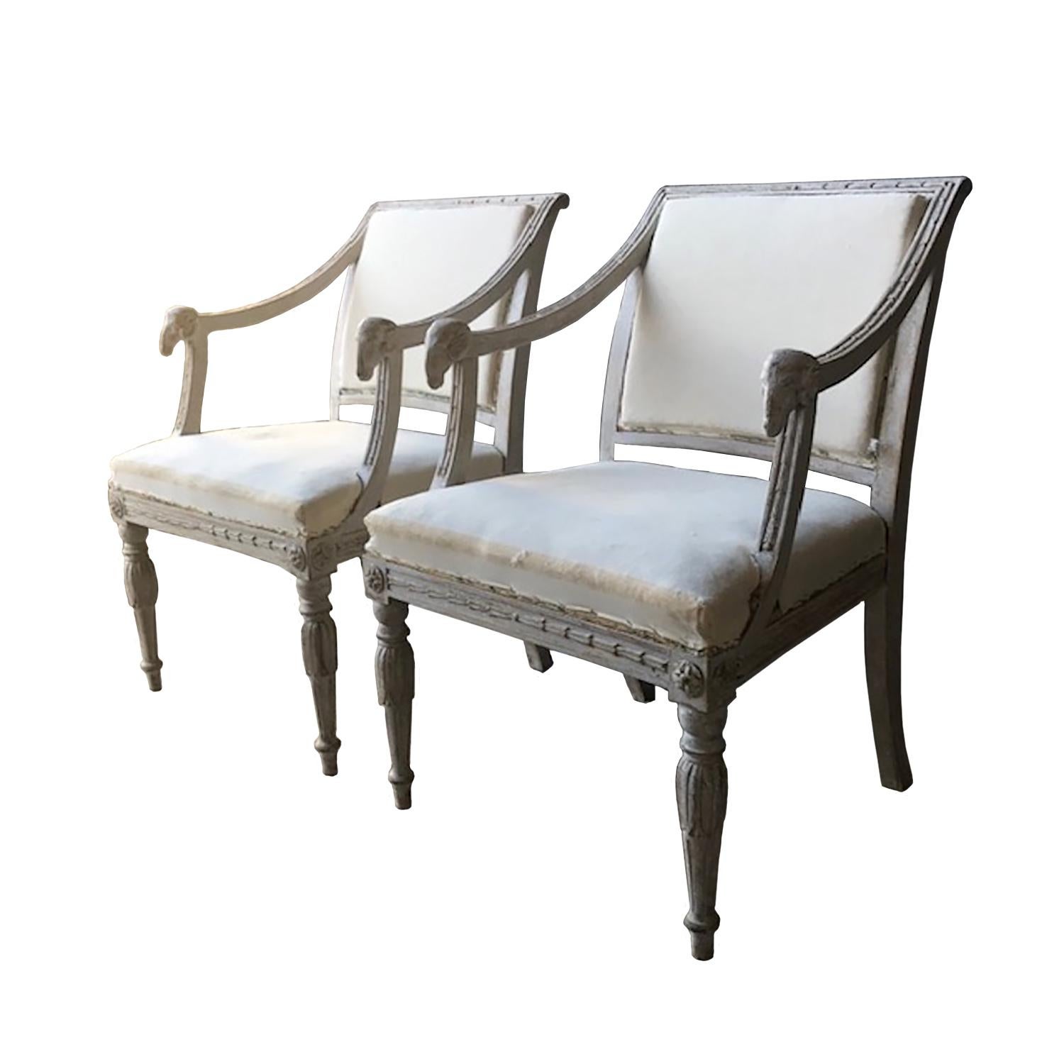 This exceptional pair of Swedish 19th century chairs feature carved decorative detailing with ram heads.