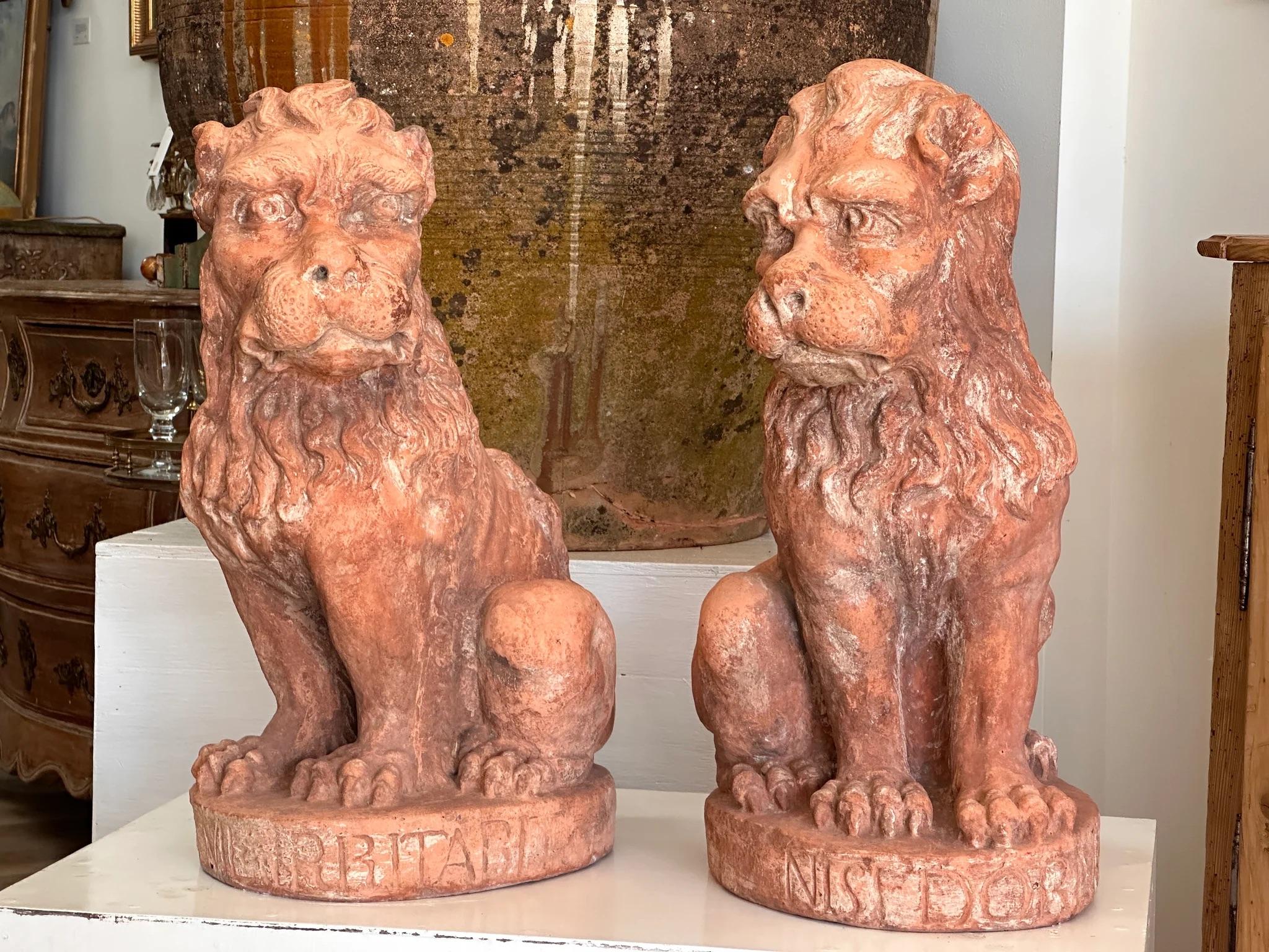 Pair of 19th Century Terra Cotta Lions, c. 1860, possibly earlier, hand modeled, likely Italian or possibly French.  For garden or indoor use.  Each modeled sitting on a circular base incised with Latin phrases.  25-1/2