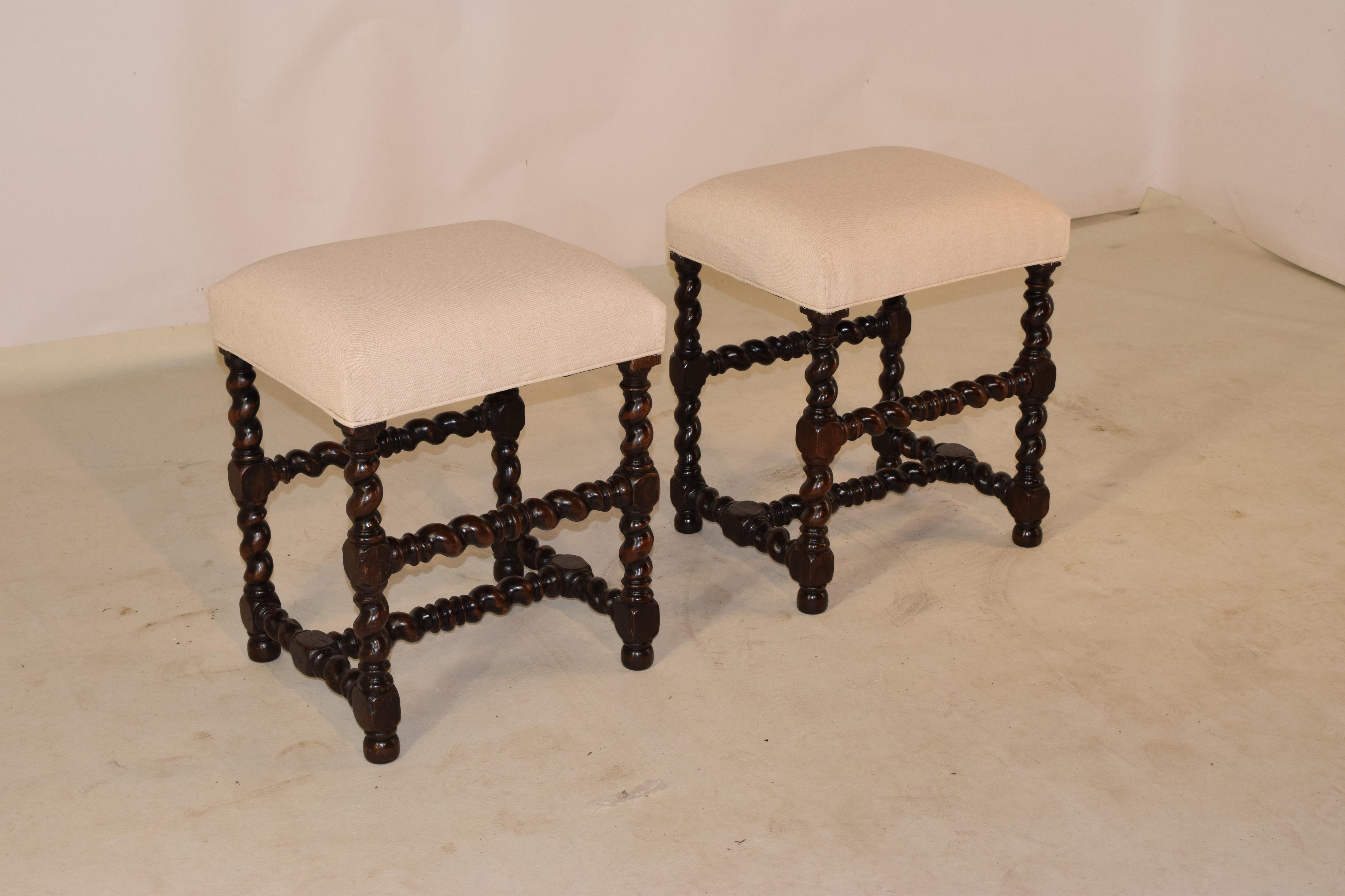 Pair of 19th century oak stools from France with newly upholstered linen seats. The frames are made from hand turned barley twist legs, joined by matching stretchers, and raised on hand turned feet.