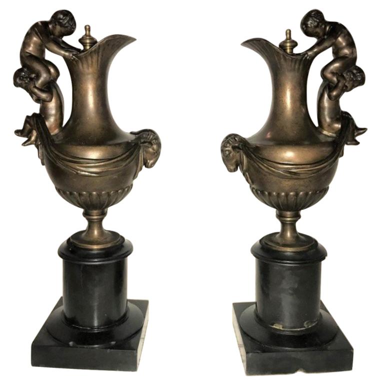 Pair of 19th Century Urns on Marble Stands Bearing Cherubs and Rams Heads