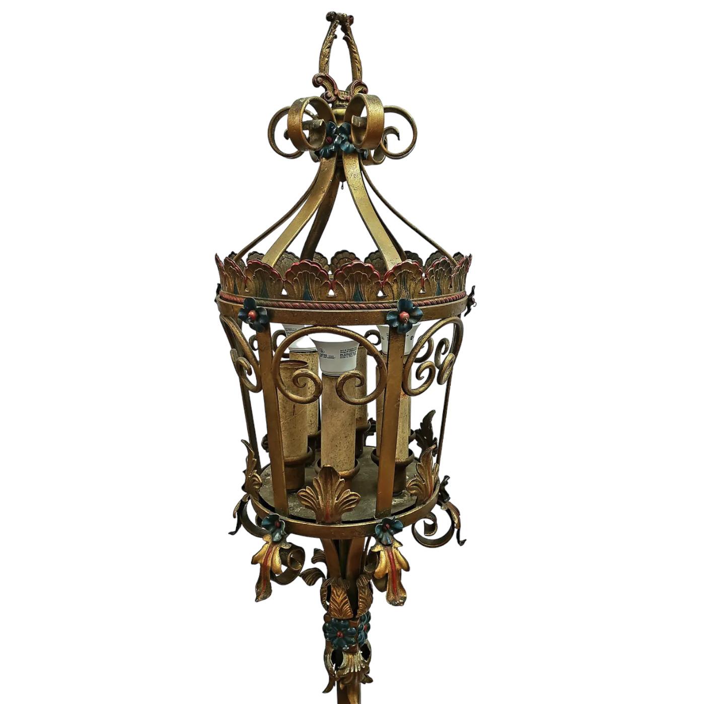 A beautiful pair of 19th Century Italian Venetian tole lanterns. Hand-forged of wrought iron, the lanterns are embellished with acanthus leaves and flower blooms, supported by a twisted rope center pole, anchored to a round heavy base. The inside of