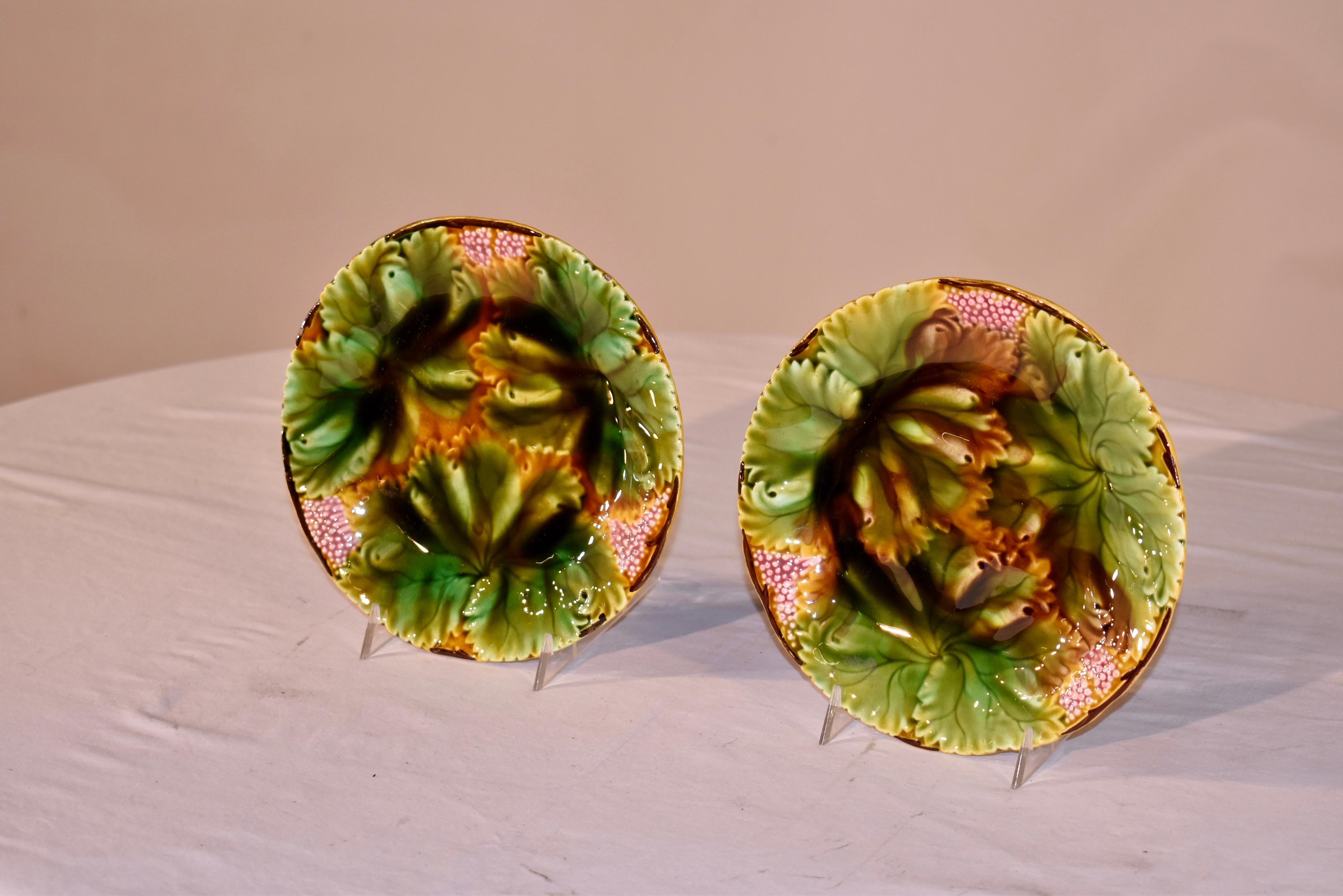 Pair of lovely late 19th century majolica plates, with manufacturer's marks on the reverse. The plates are in lovely colors of brown, green, gold and pink. There are three prominent leaves overlapped in this pattern, with sprays of berries in
