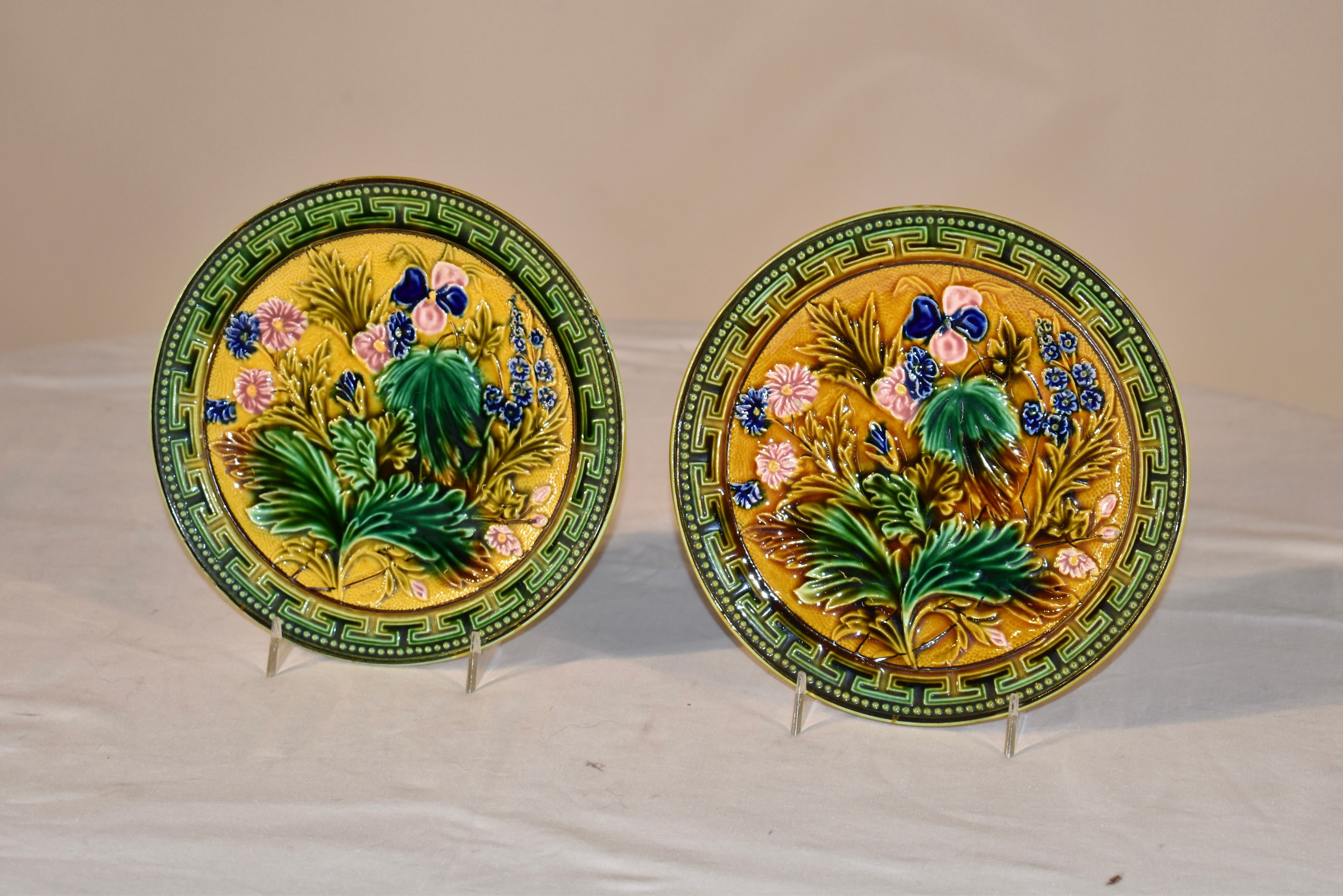 Paar Majolikateller aus dem 19. Jahrhundert mit einem wunderschönen Blumenmuster.  Die Grenzen der Platten sind in einem griechischen Schlüssel Art Muster und sind auch in Perlen  schöne Grüntöne.  In der Mitte der Teller befindet sich ein goldener