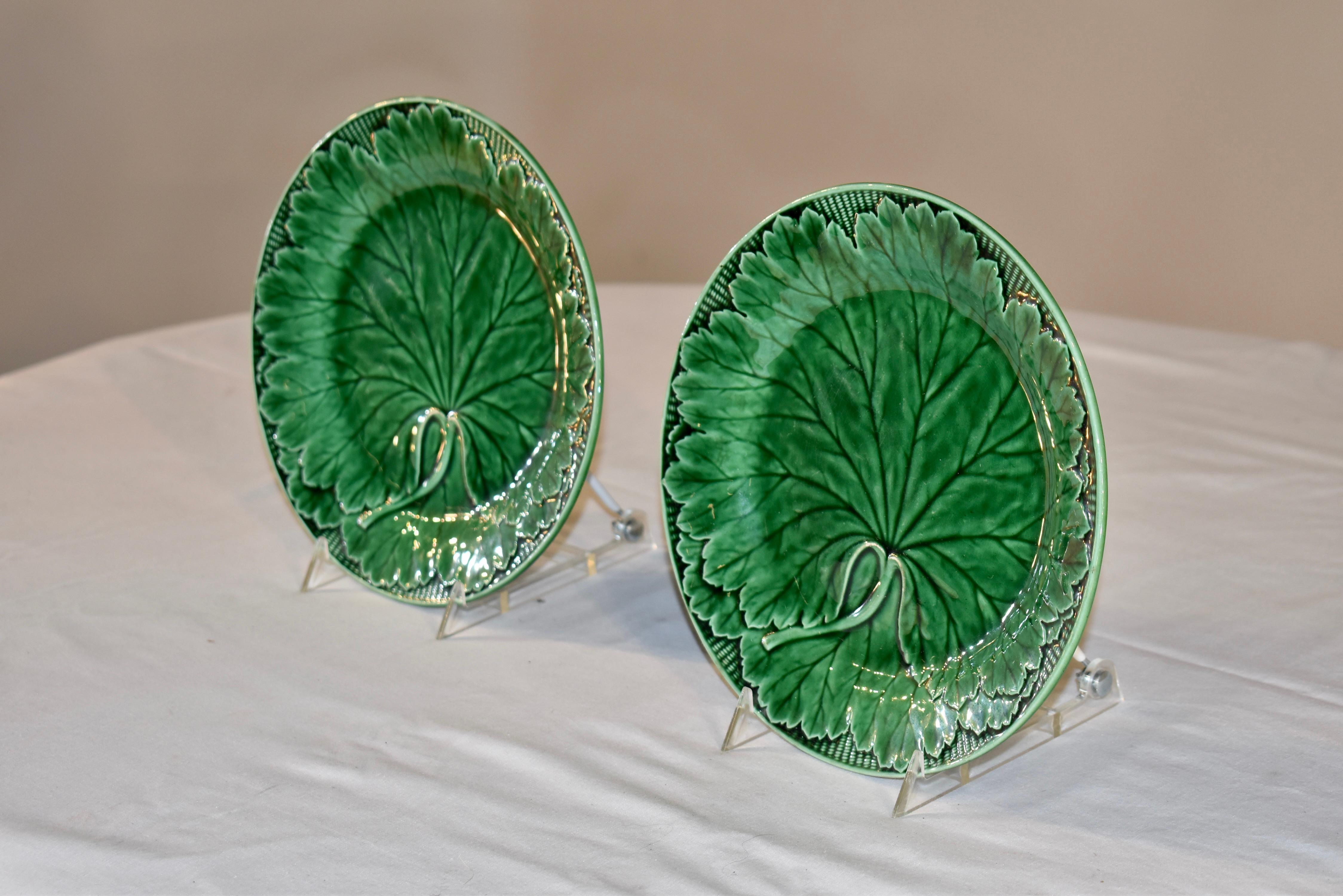Pair of 19th century Wedgwood majolica plates in a rich shade of green.  the molds are crisp and have loads of detail in the leaves and surrounding basketweave design.  The pieces have the impressed mark WEDGWOOD on the backs.  