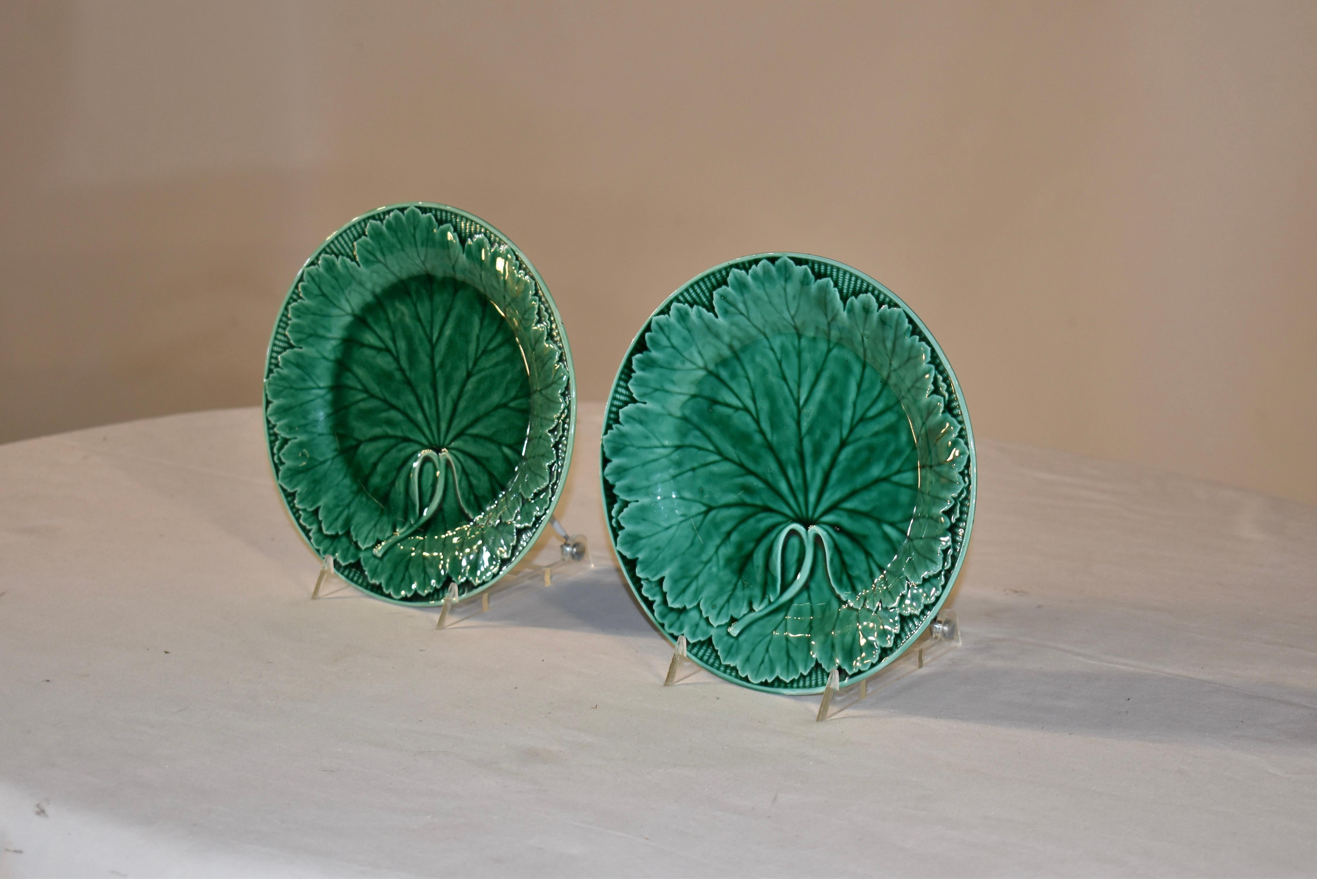 Paar Wedgwood Majolikateller aus dem 19. Jahrhundert in satten Grüntönen. Die Formen sind gestochen scharf und weisen viele Details in den Blättern und dem umgebenden Korbflechtmuster auf. Die Stücke tragen auf den Rückseiten die eingeprägte Marke