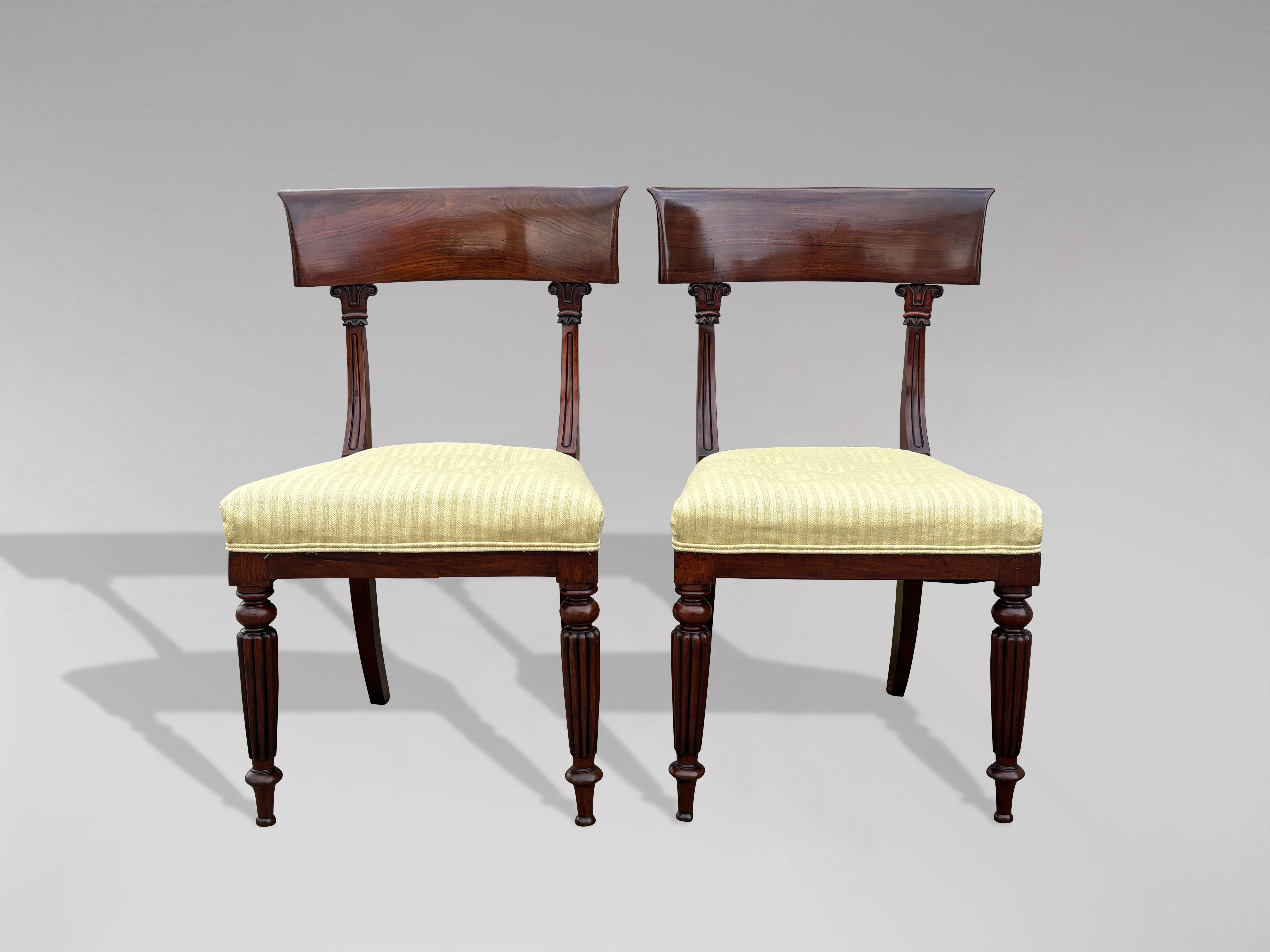 A pair of 19th century William IV period fine quality solid mahogany bar back side chairs with newly upholstered seats, in excellent condition. These strong chairs are designed with an attractive curved bar back connected to shaped, carved reeded