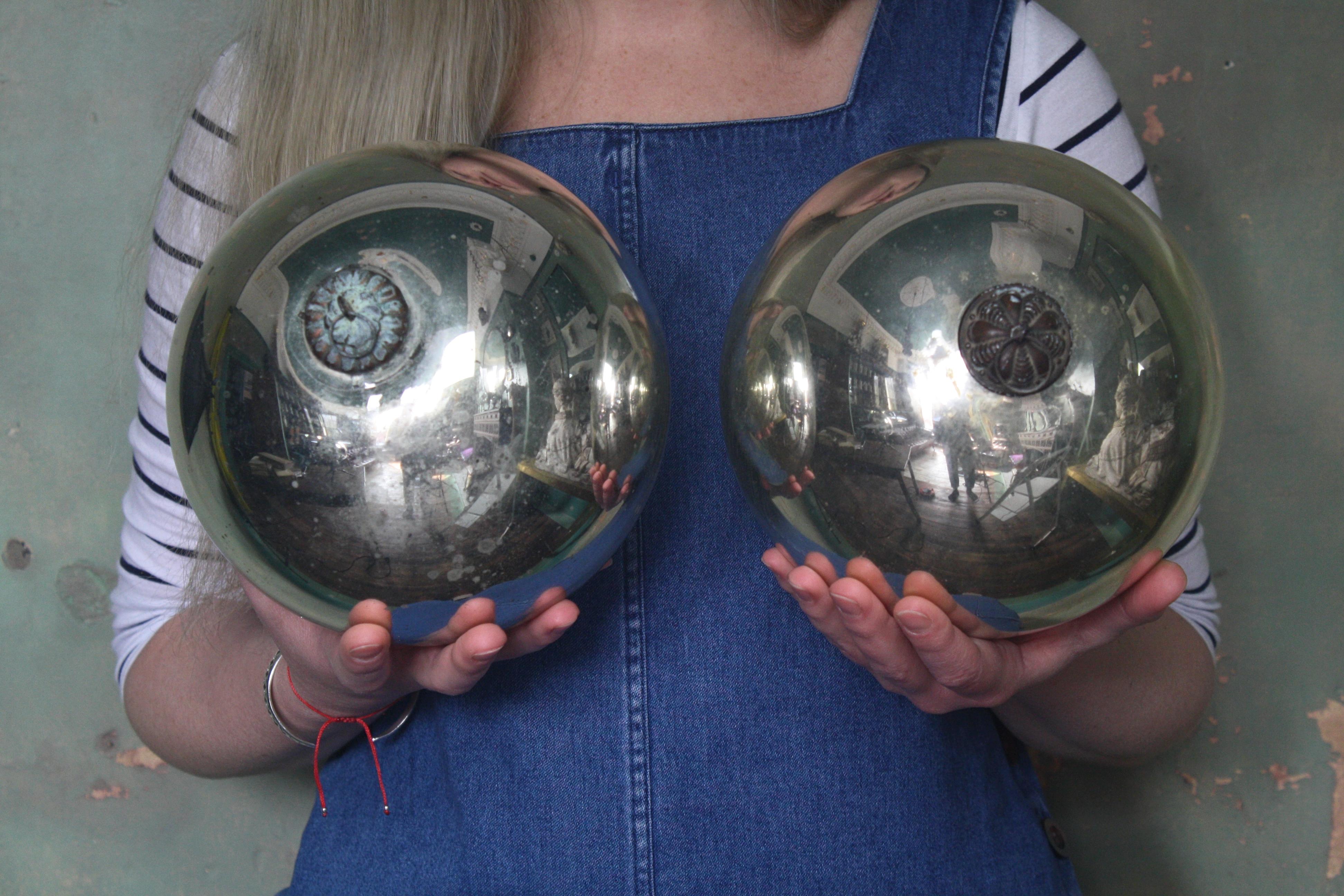 A pair of late 19th century balls with pressed copper galleries, both have pitting and oxidation consistent with age. One ball has a large section of deterioration to the bottom approx. measurements of both 18.5cm in diameter, 21.5cm in drop, 58cm