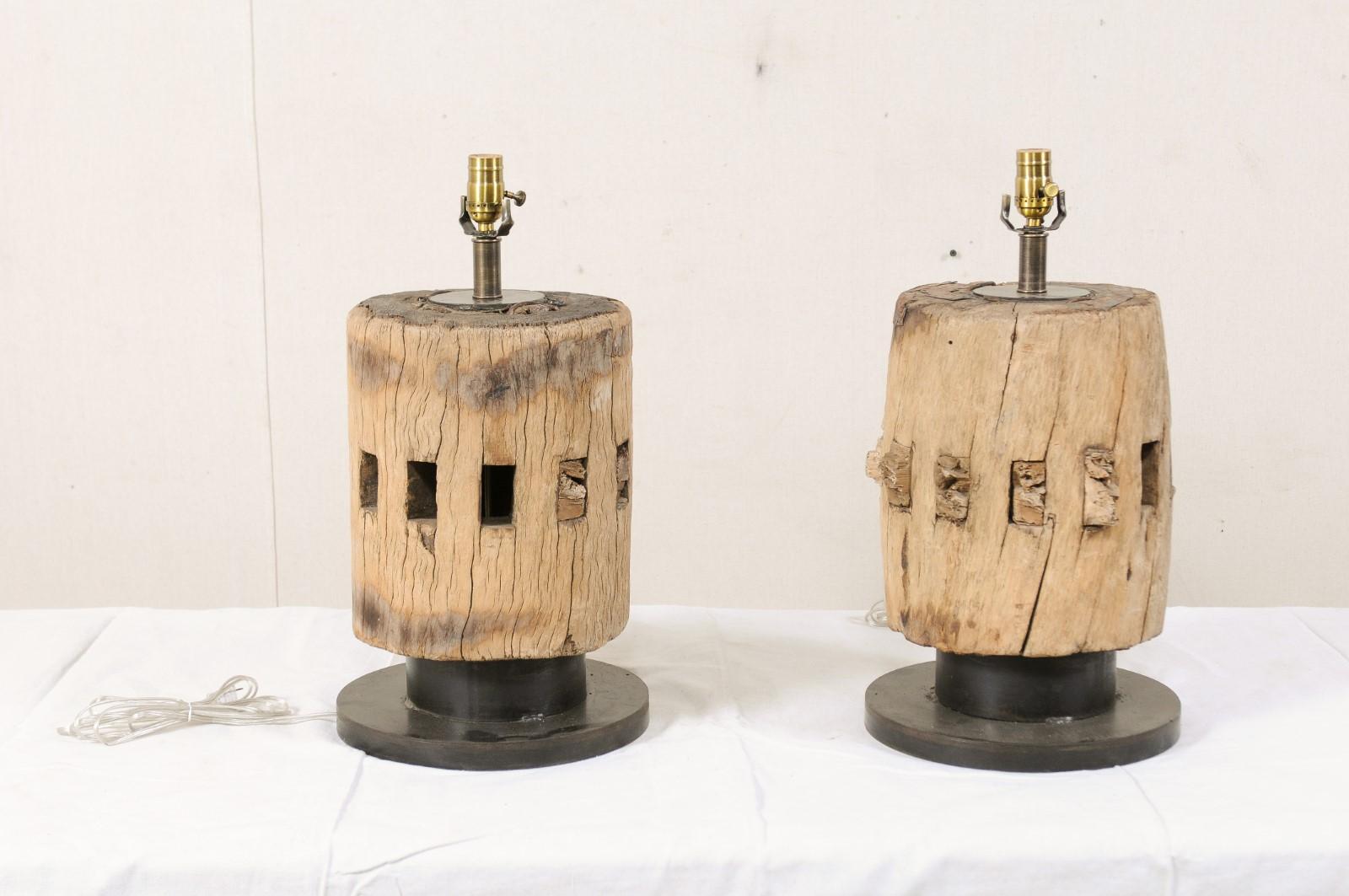 A pair of table lamps with French wood cog column bodies from the early 19th century. This pair of table lamps have been custom fashioned from a cut section of a 19th century wooden cog (or gear) from France, with nicely notched cut-outs about their
