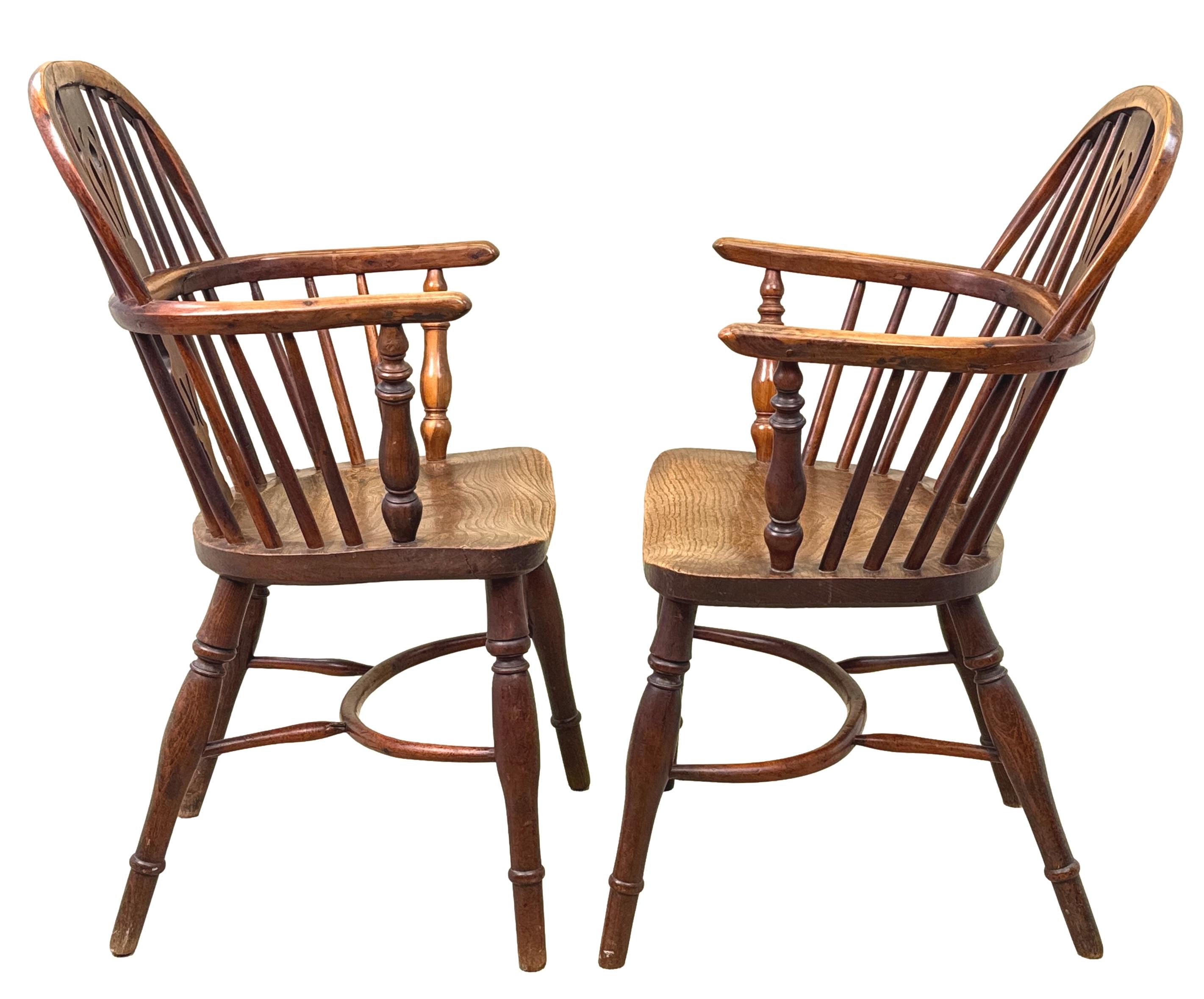 Un'elegantissima coppia di poltrone da cucina Windsor con schienale basso in Wood Wood, risalenti all'inizio del XIX secolo, che presentano eleganti spacchi e sostegni torniti a schienali curvi, sedili sagomati e gambe tornite unite da bretelle in