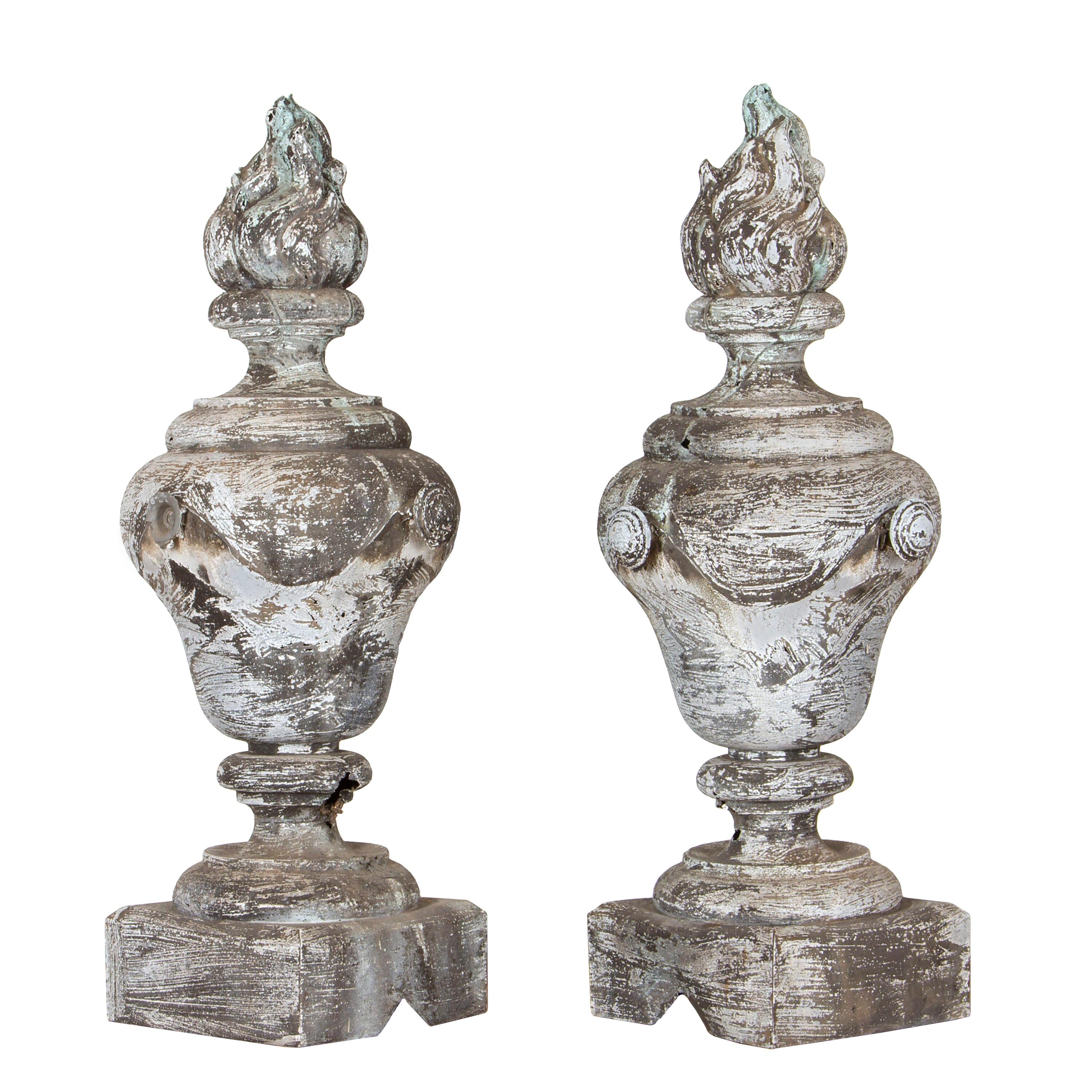 Lovely pair of 19th Century zinc finials. 
This decorative pair of finials feature detailed flame tops with a lovely swag decoration to the circumference. Terminating on a square zinc base. 
A decorative pair that will make for a great feature