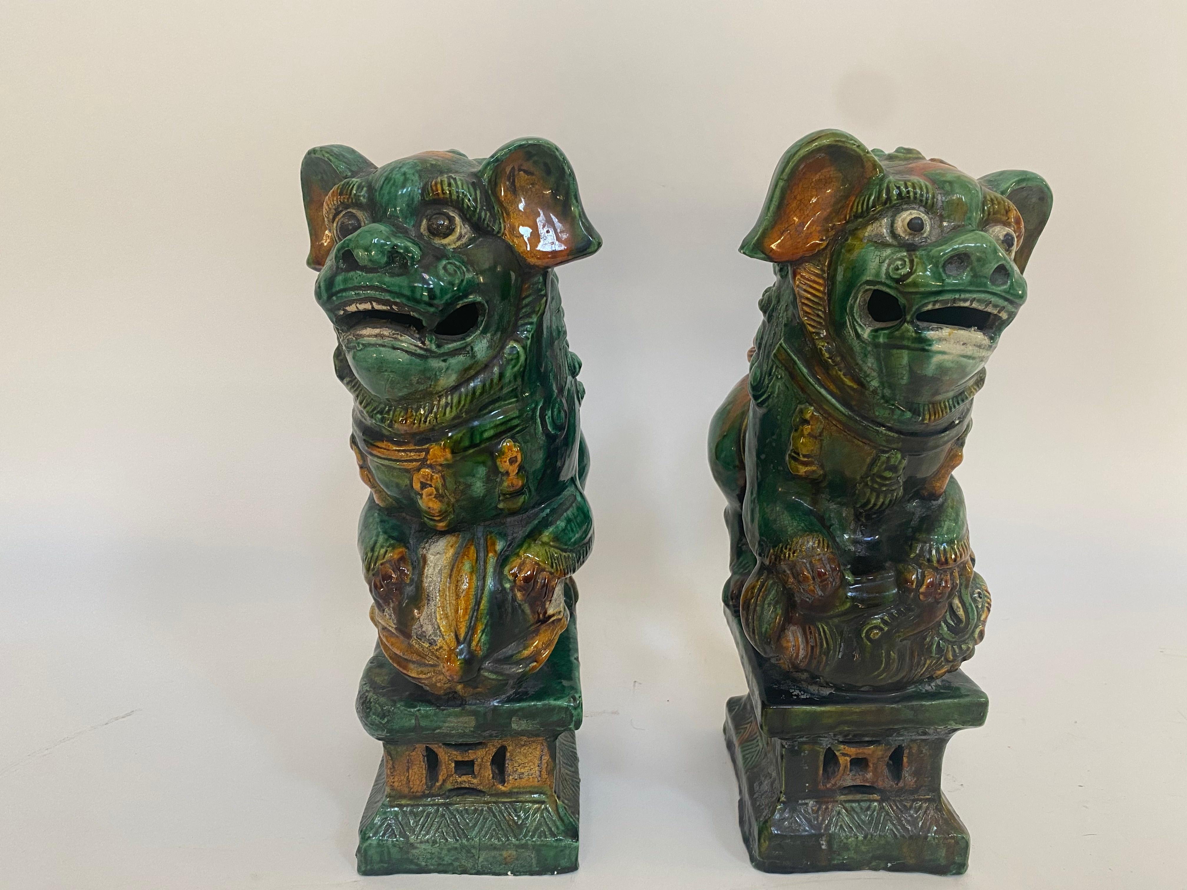 19th century Chinese tri-colored glazed foo lions.
Beautiful pair of antique Chinese foo lions/dogs. The glaze still shines, there are minor chips here and there. Always standing in pairs, foo dogs are fantasy lions in Chinese mythology who serve