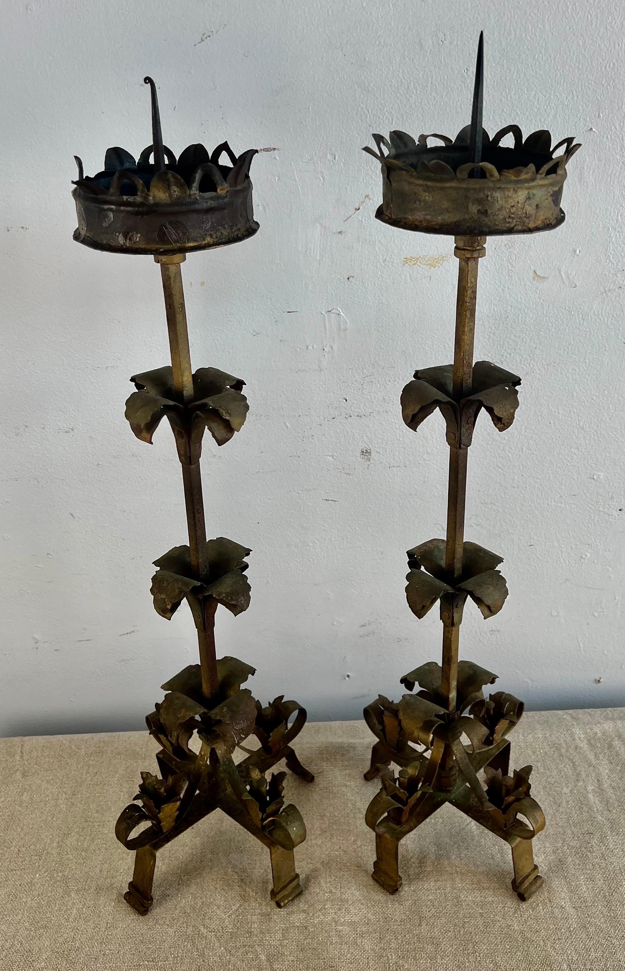 Pair of 19th century Spanish hand wrought iron candlesticks. The candlesticks are beautifully detailed with scrolls, leaves and flowers that have developed a great patina over the years.