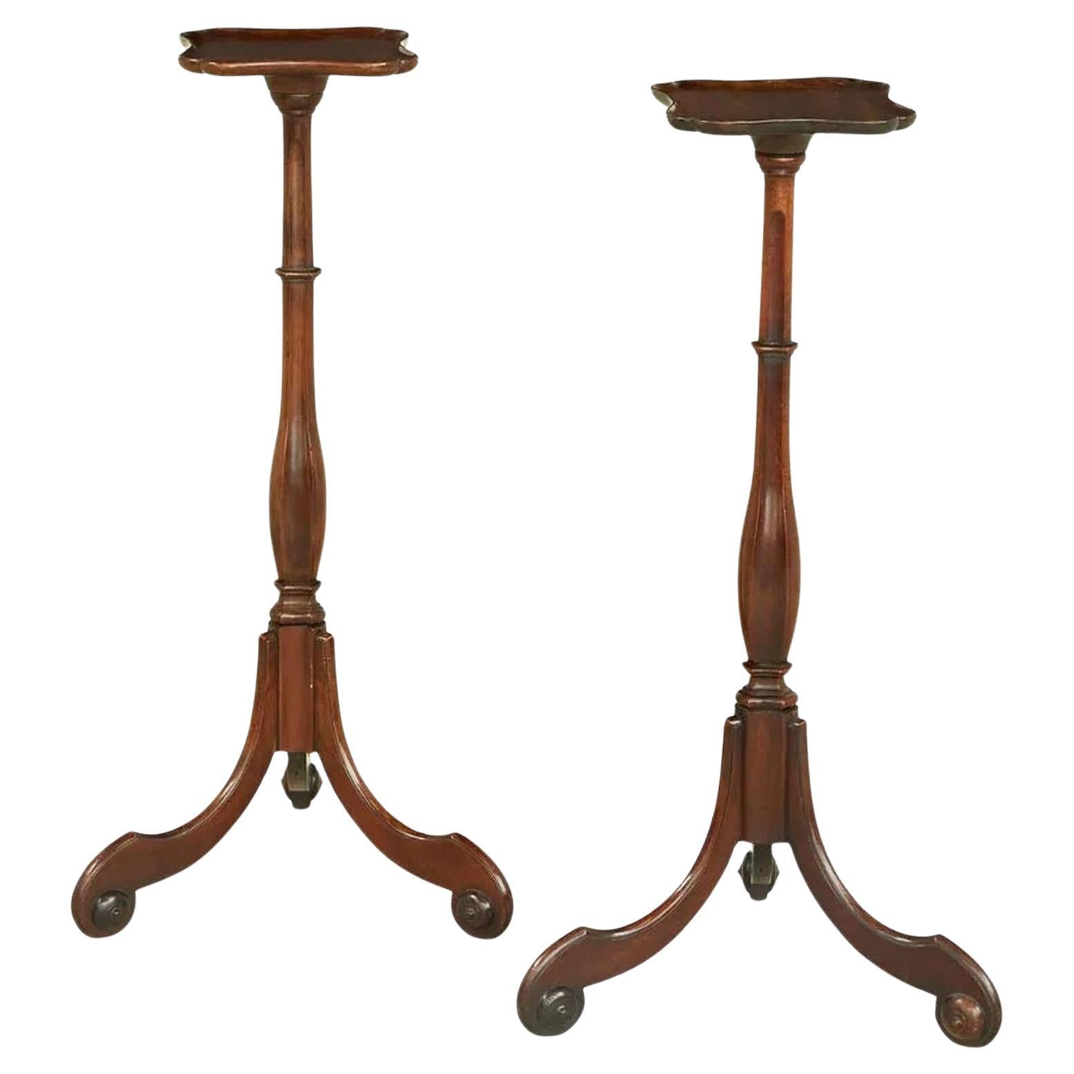 Stunning pair of 19th century Chippendale period mahogany Torchière stands. Square tops have slightly raised edges and are supported on carved slender turned columns, raised on ornate tripod supports with scrolled feet. 
Torchières were used as